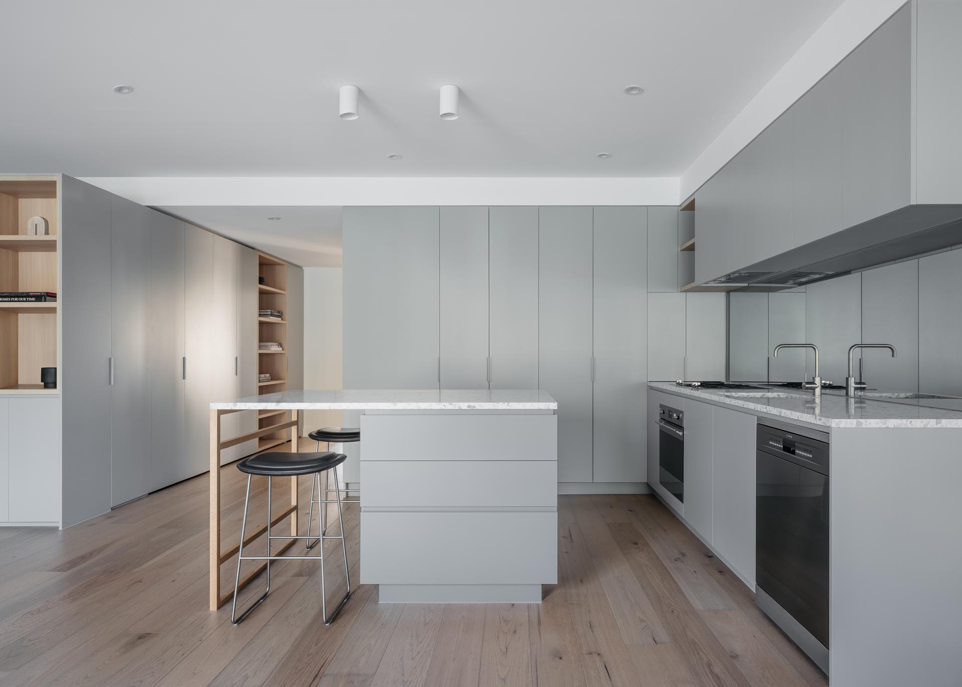 A modern kitchen with minimalist light gray cabinets and an island.