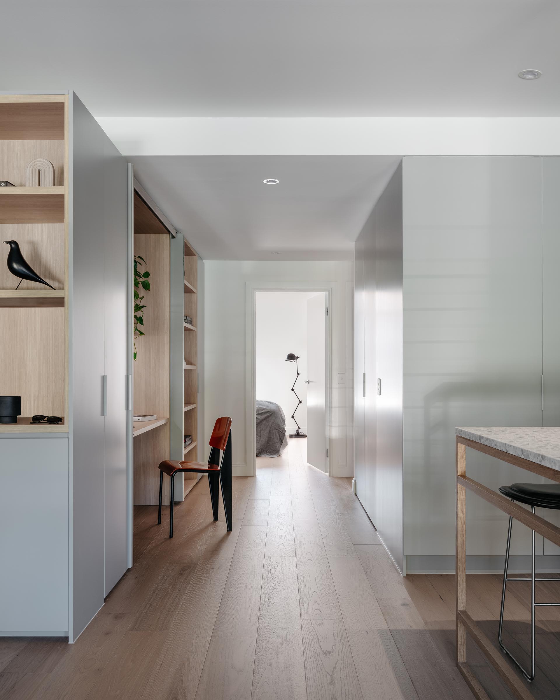 A modern wood-lined home office hidden within a closet.