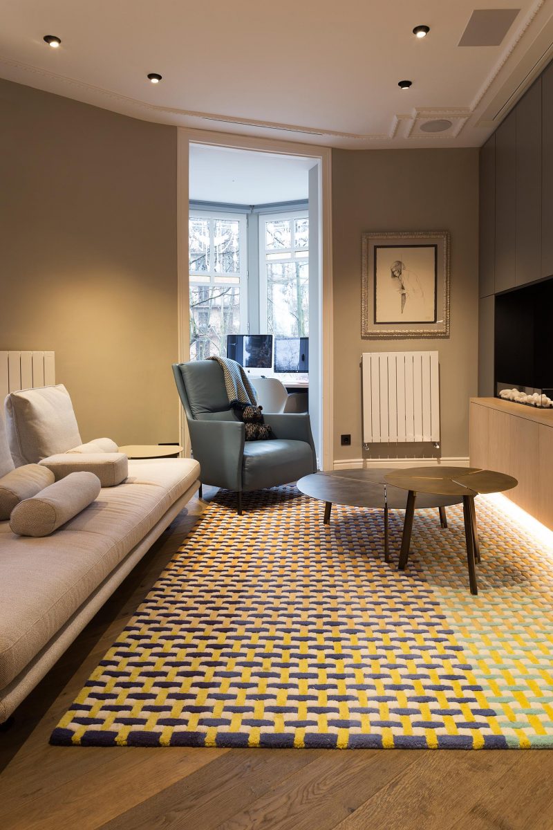 A modern living room with a colorful rug.