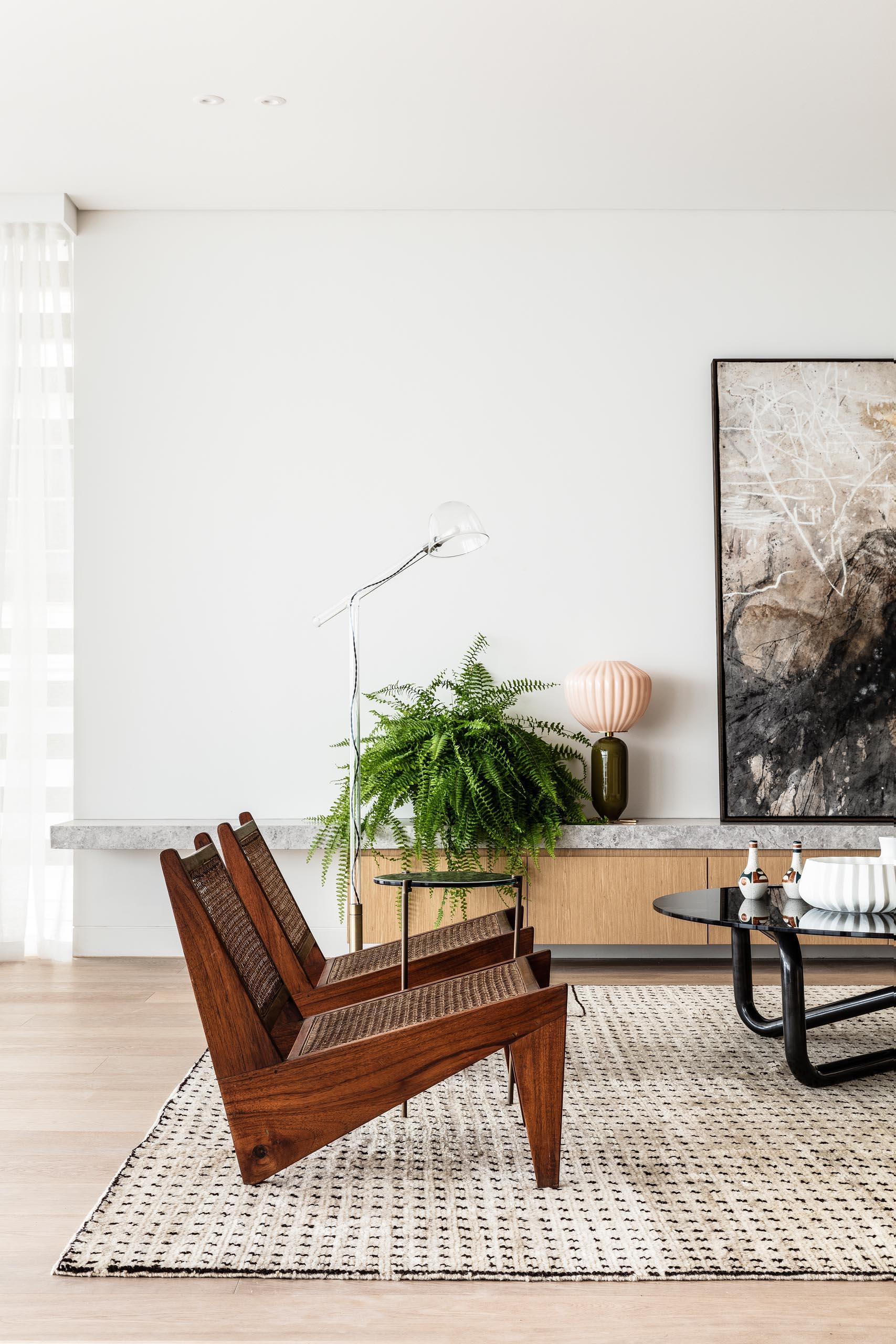 A large rug anchors this living room, while a low cabinet provides a place to display artwork, plants, and decor.