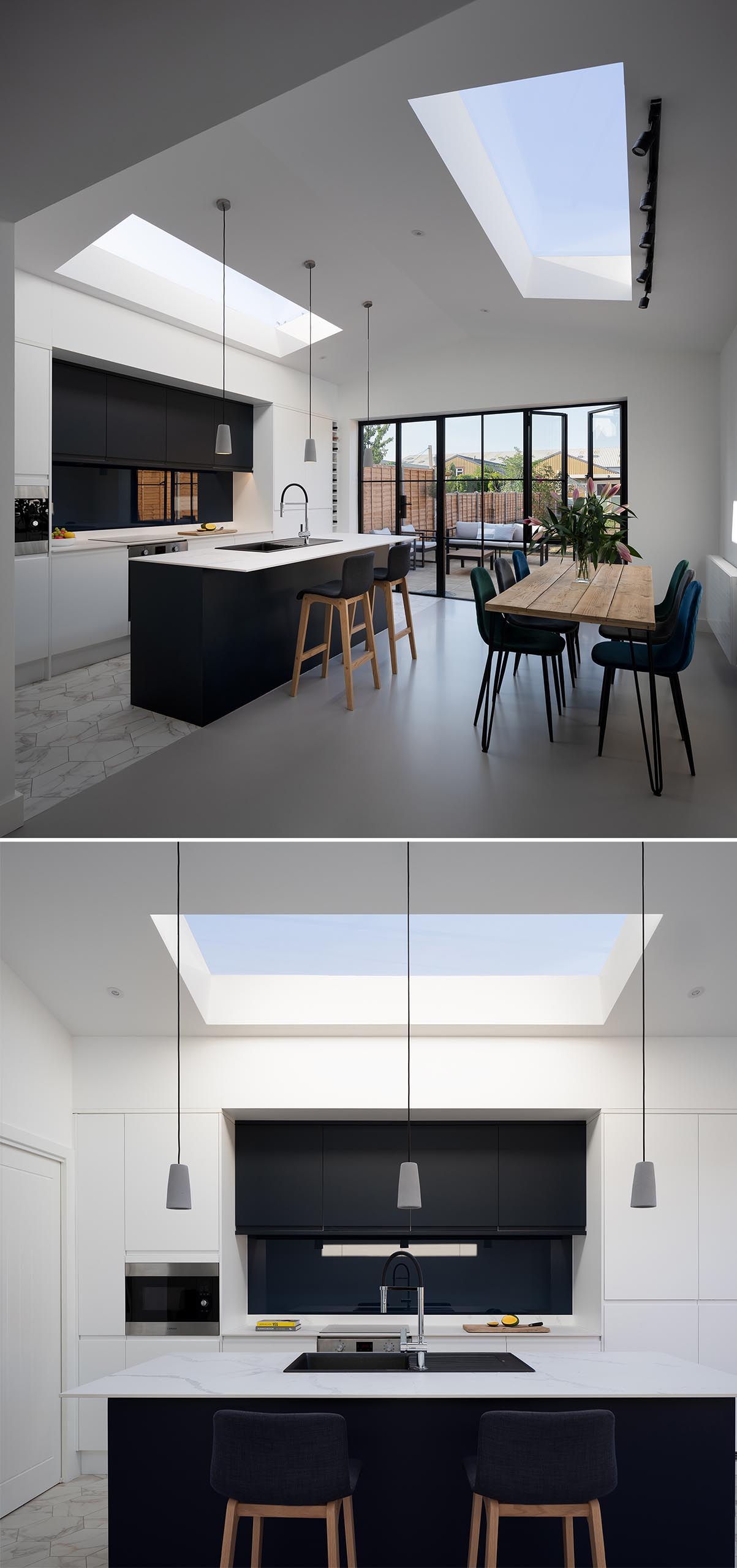 A modern open plan kitchen and dining room with a pitched ceiling and skylights.