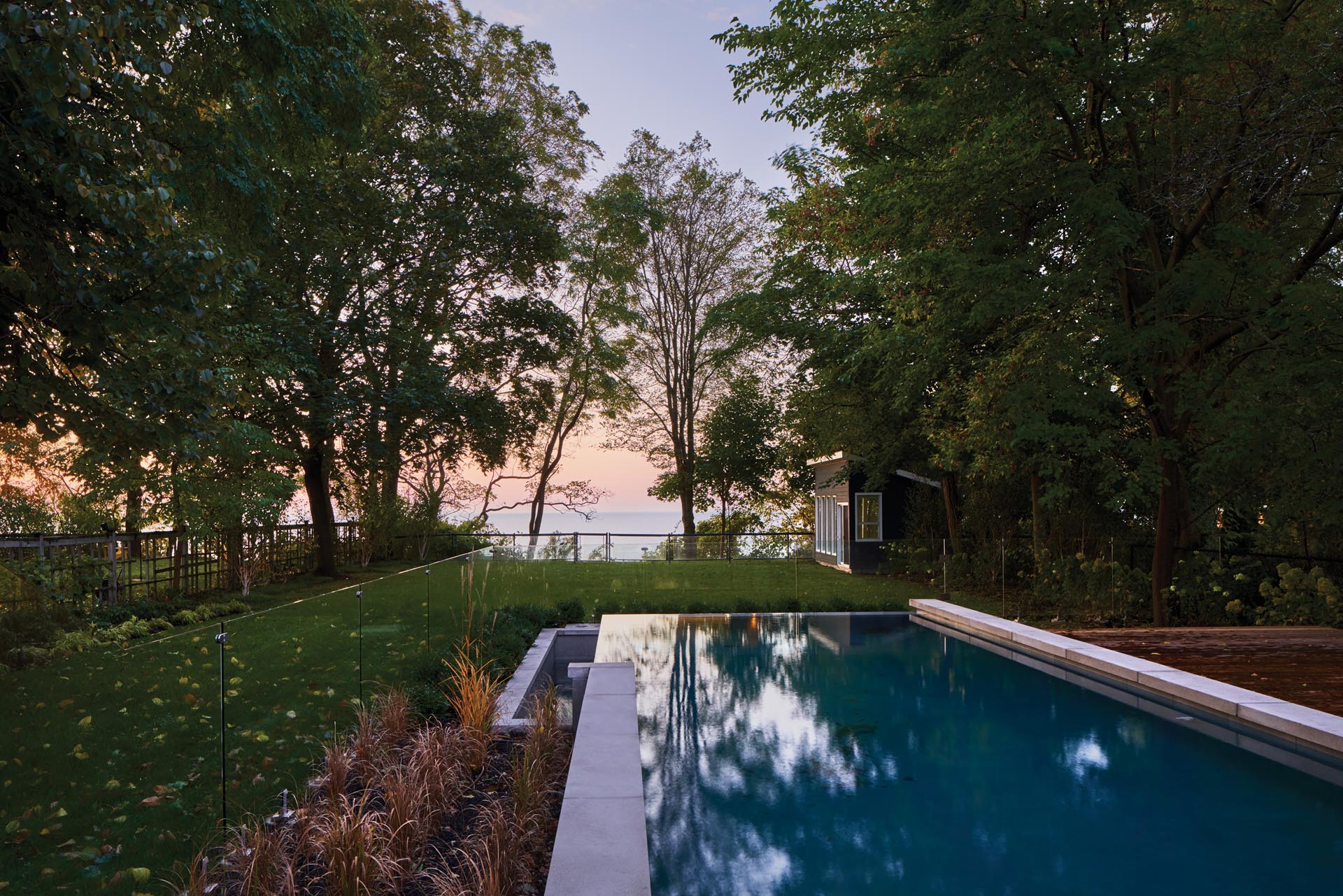 A landscaped yard with a swimming pool and small shed.