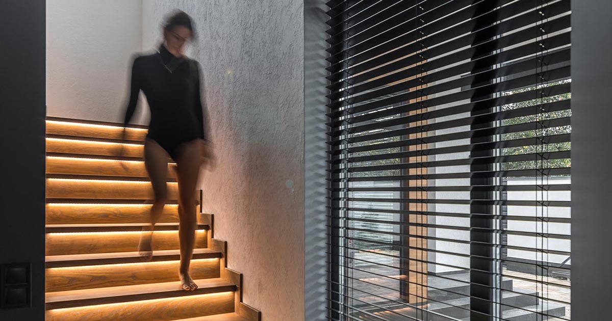 A Strip Of LED Lights Under The Stairs Of This Home Adds A Warm Glow To The Interior