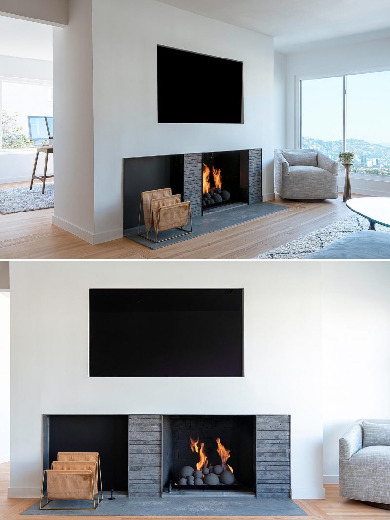 A set back fireplace with a dark grey surround has space for firewood or magazine storage, while above, a television has been recessed into the white wall.