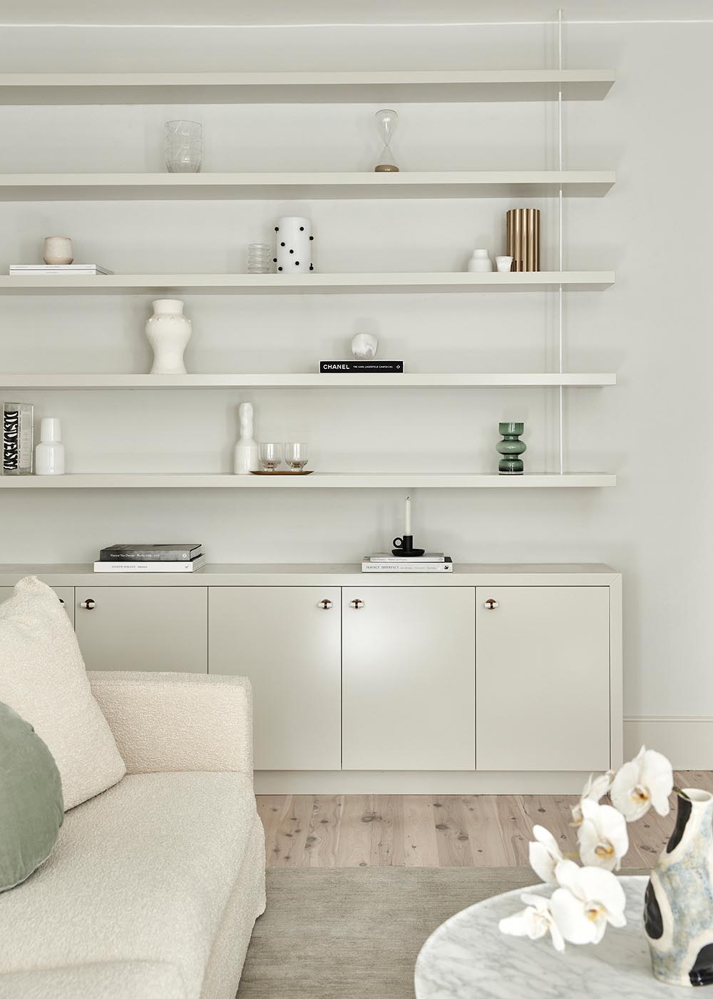 Custom cabinetry and shelving almost seamlessly blend into the wall, allowing the decorative objects to stand out.