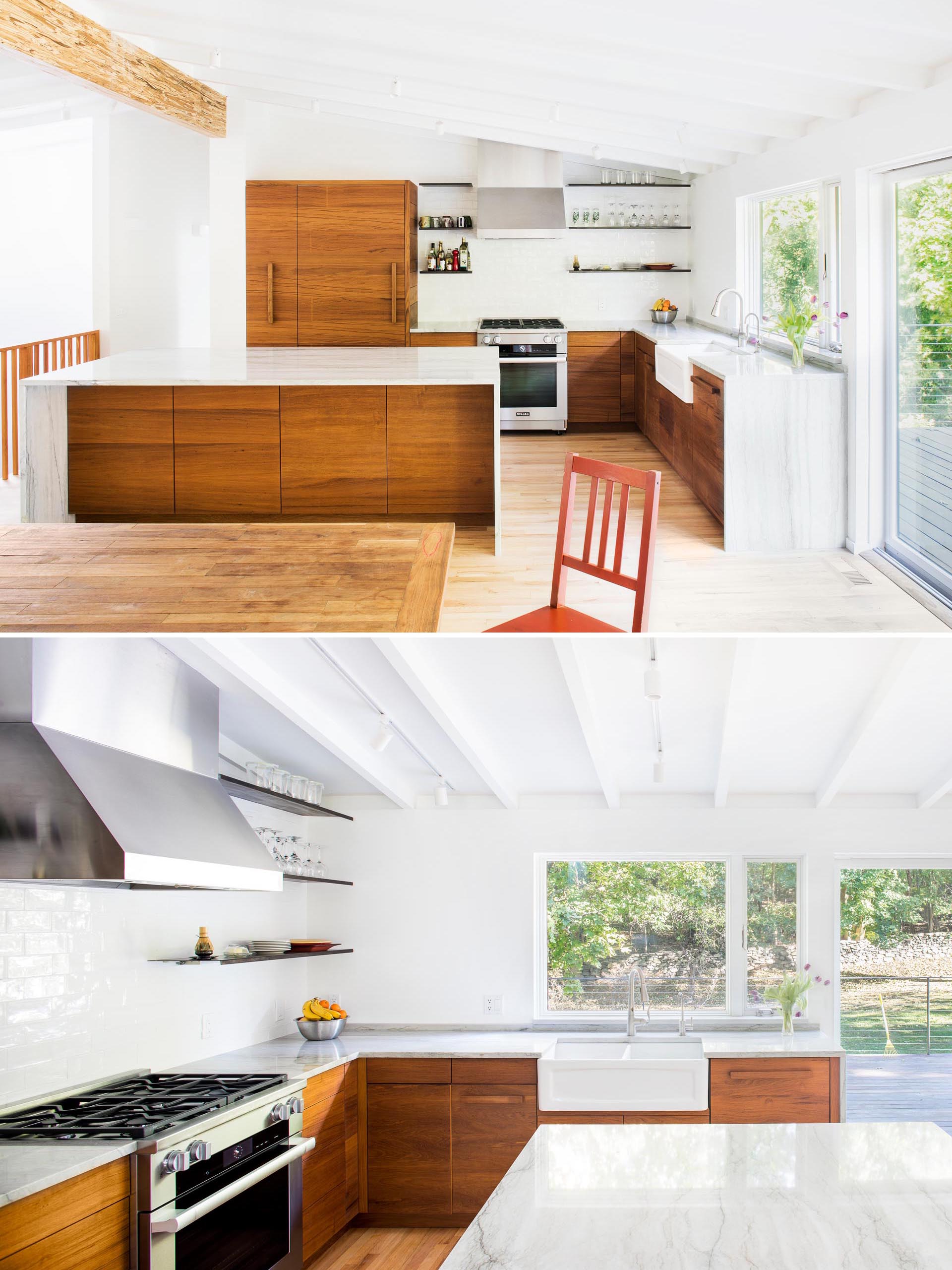 The remodeled kitchen includes wood cabinets, an island with a waterfall countertop, a white apron sink, and floating wood shelves.