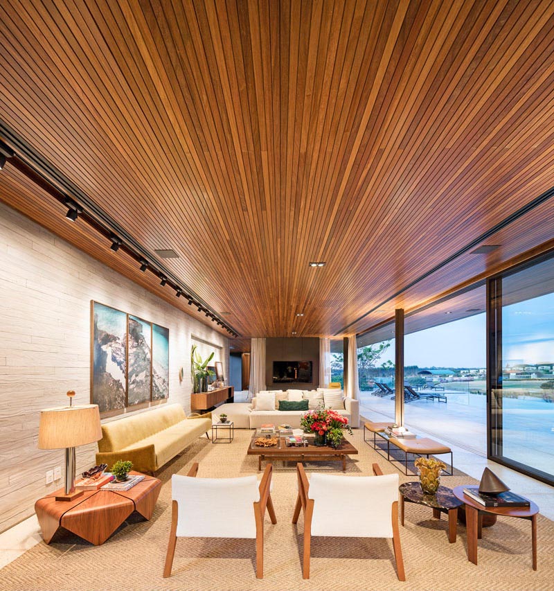 A modern living room with an uninterrupted wood ceiling.