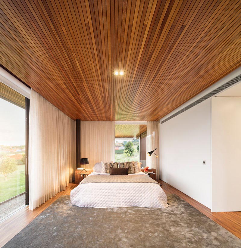 A modern bedroom with a wood ceiling.