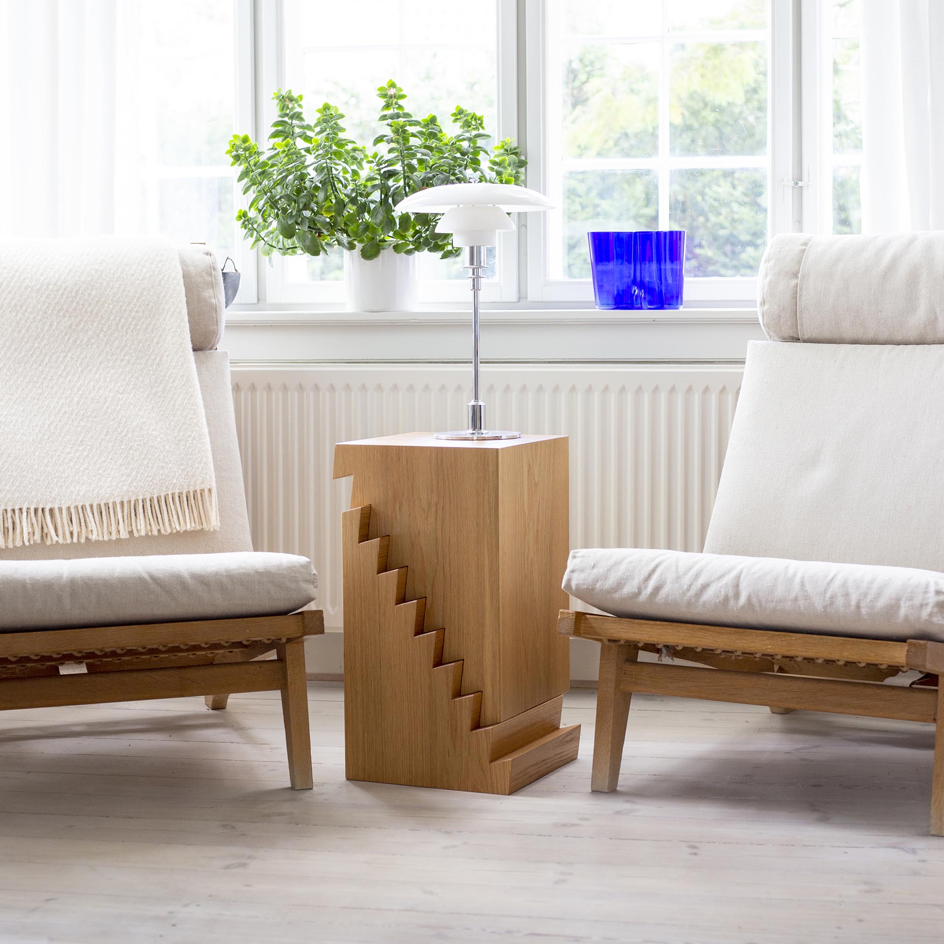 A modern wood side table with a saw-tooth design.