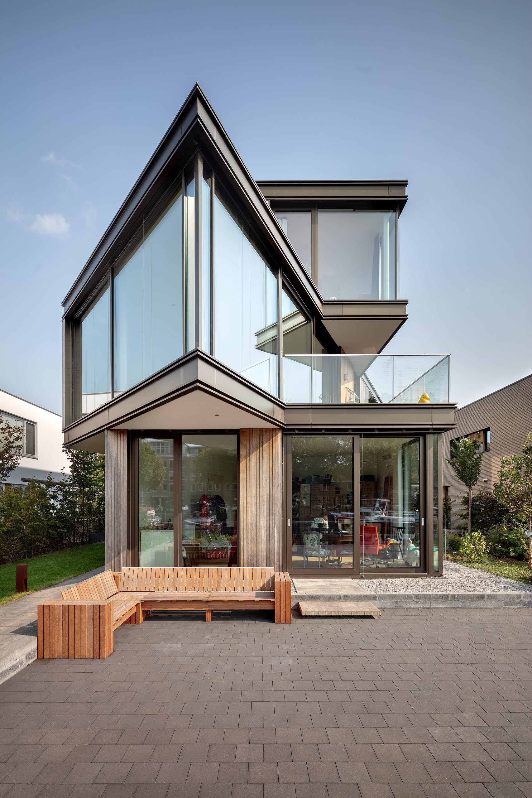 A modern house with a sharp angle and glass walls.