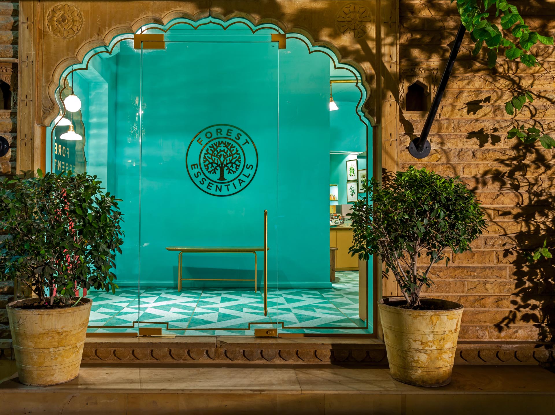 A retail store entryway with teal walls and a gold logo.