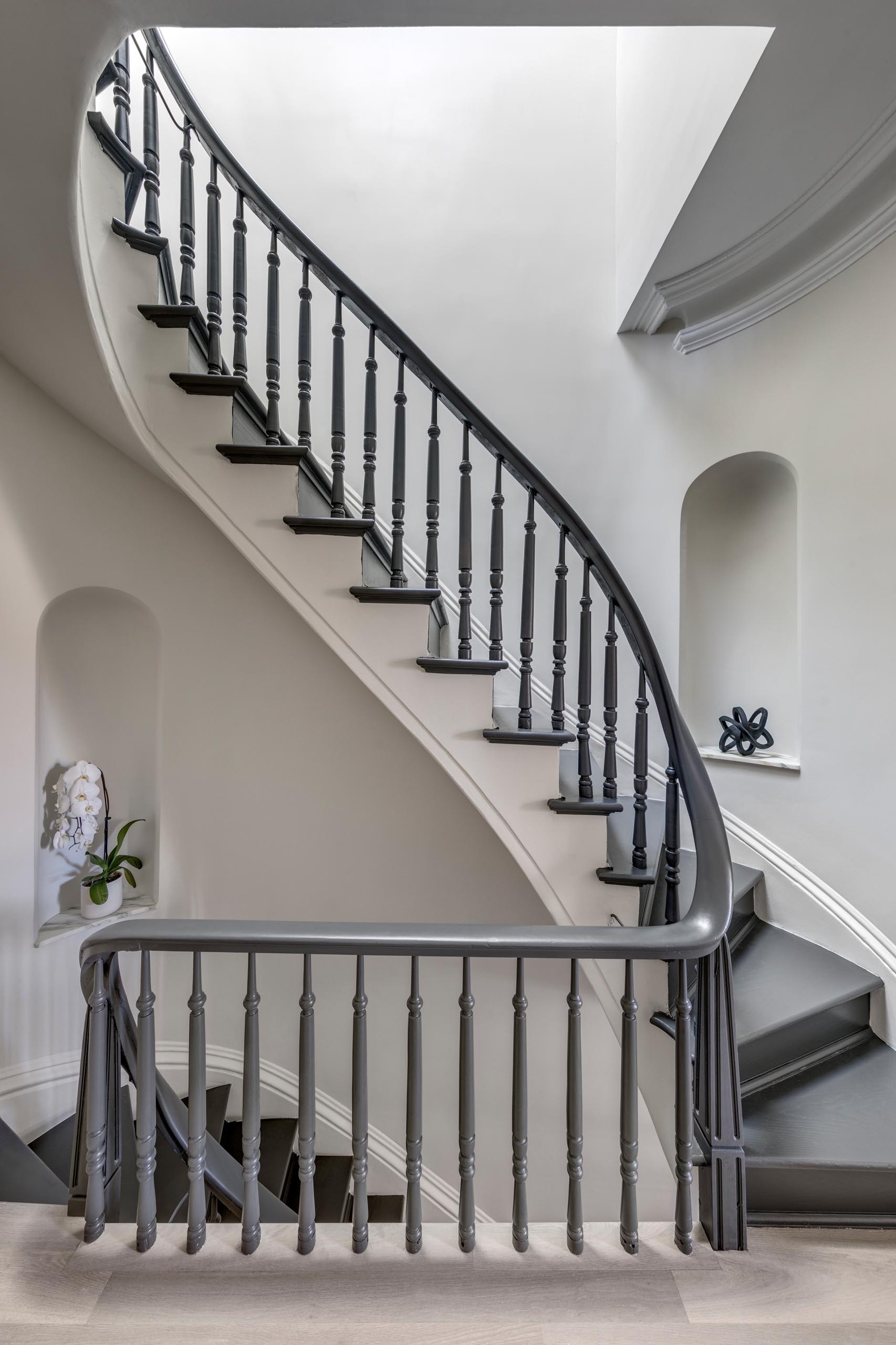 A staircase with a grey handrail and matching stair treads.