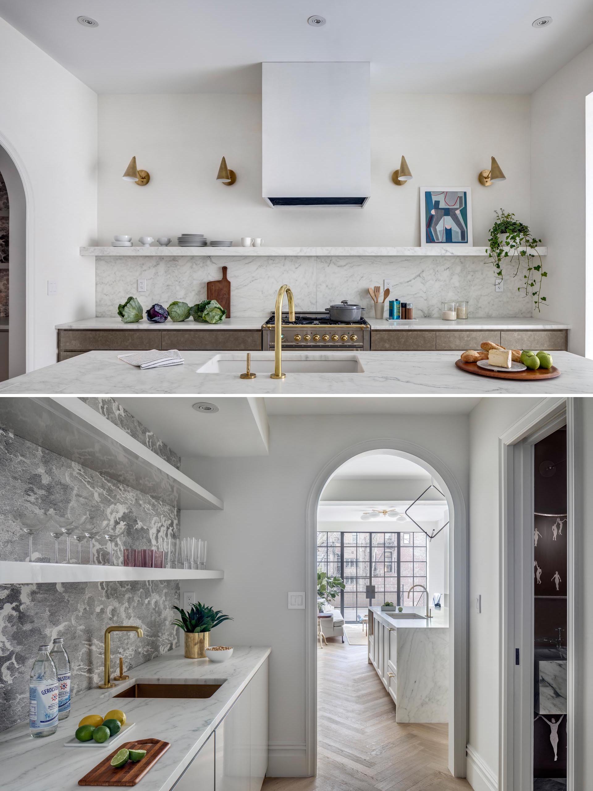 A modern kitchen with marble countertops, an undermount sink, bronze hardware and lighting, and a butler's pantry.