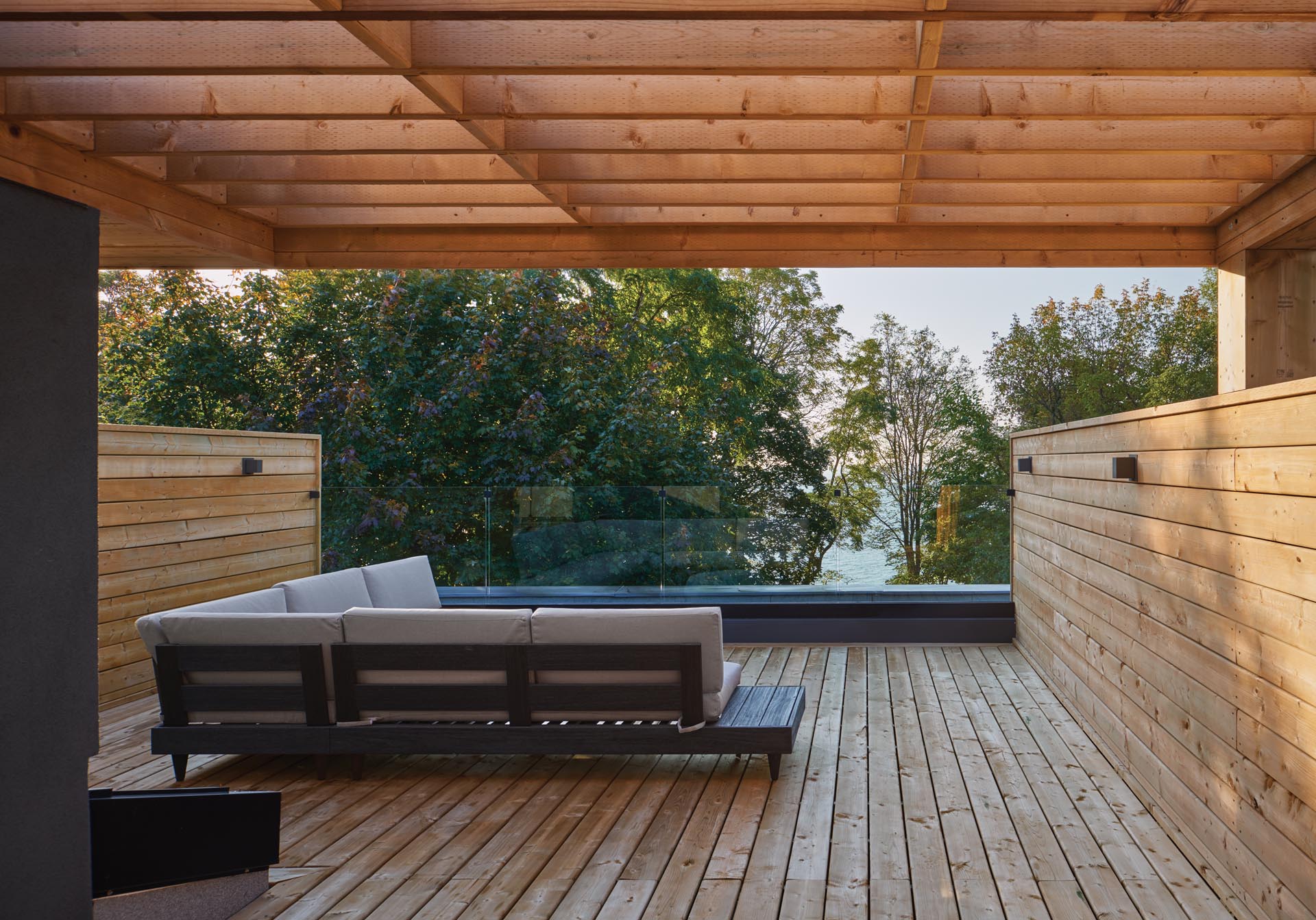 A wood rooftop terrace with a pergola.