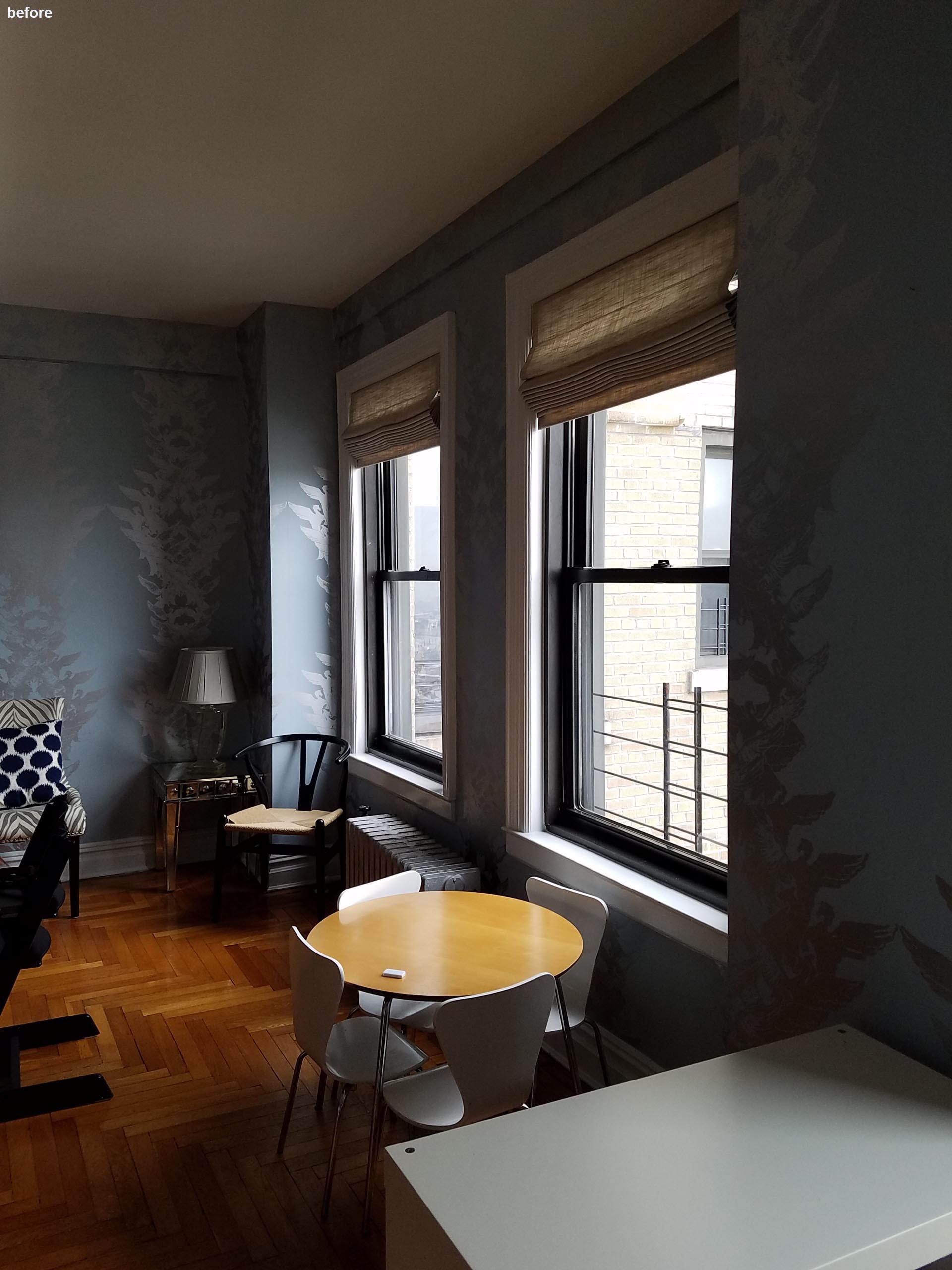 Before photo - a dining room with patterned wallpaper.