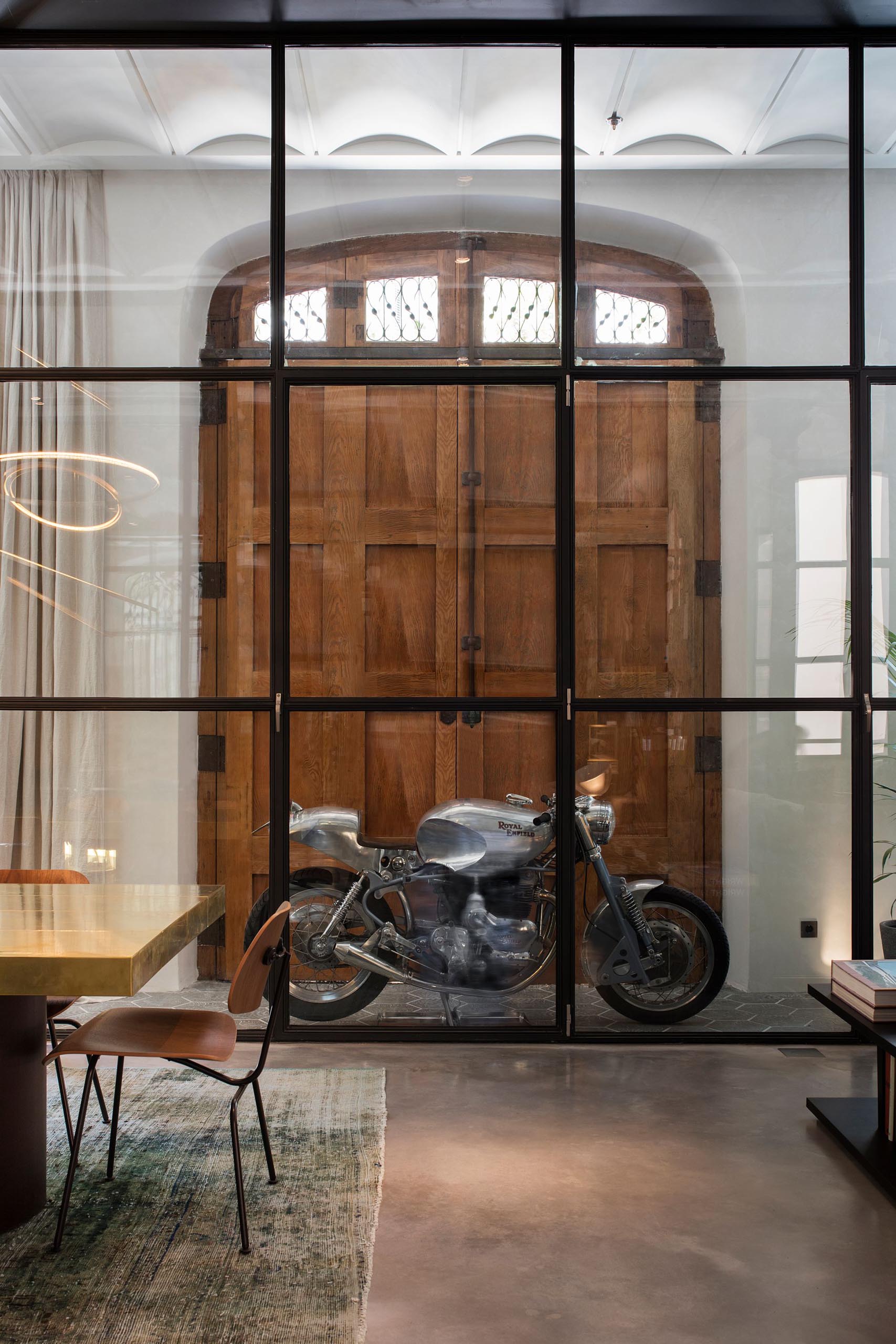 A wall of glass separates the entryway from the open plan interior of this modern apartment.