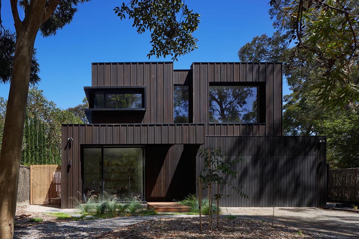 The exterior of this modern home showcases Blackbutt timber cladding that's accented by black metal window frames.