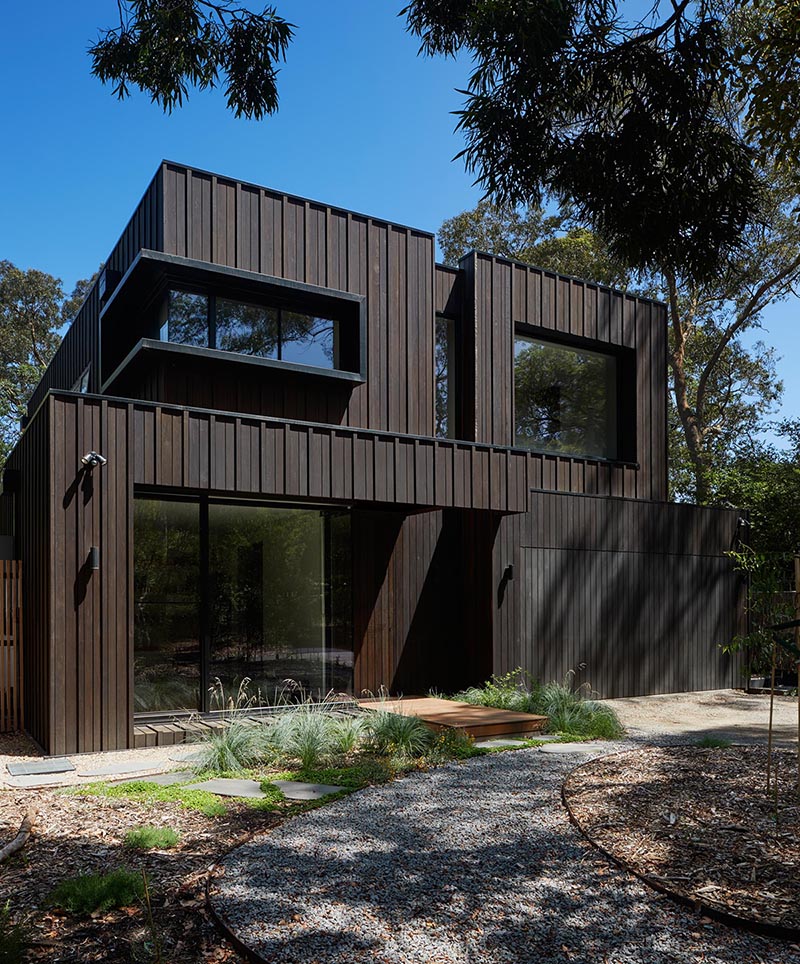 The exterior of this modern home showcases Blackbutt timber cladding that's accented by black metal window frames.