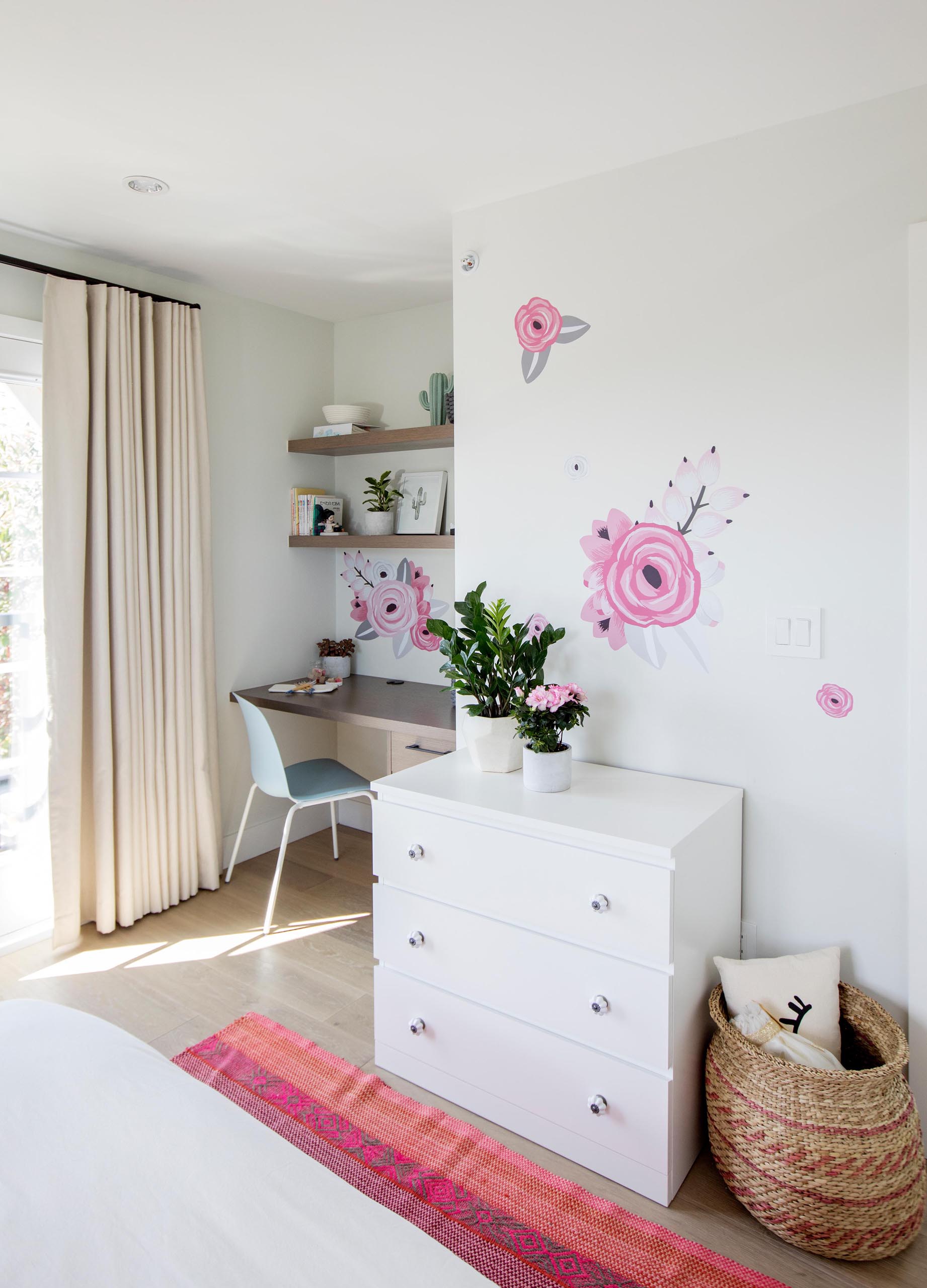 A modern desk with floating shelves has been included in a small alcove in a bedroom.