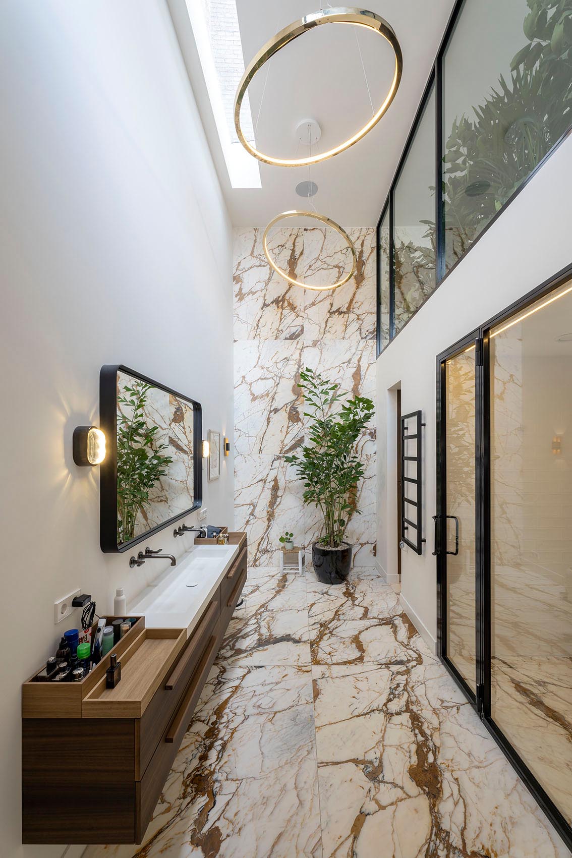 A modern bathroom with a long thin vanity, and a skylight.