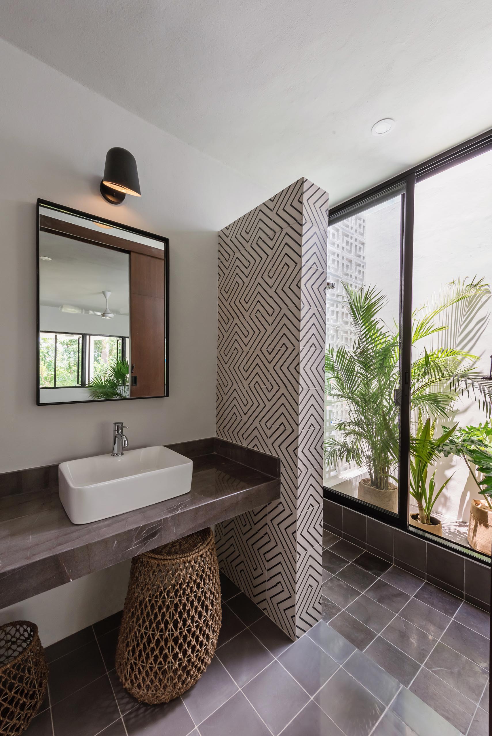 In this modern bathroom, graphic tiles have been used to separate the shower from the vanity.