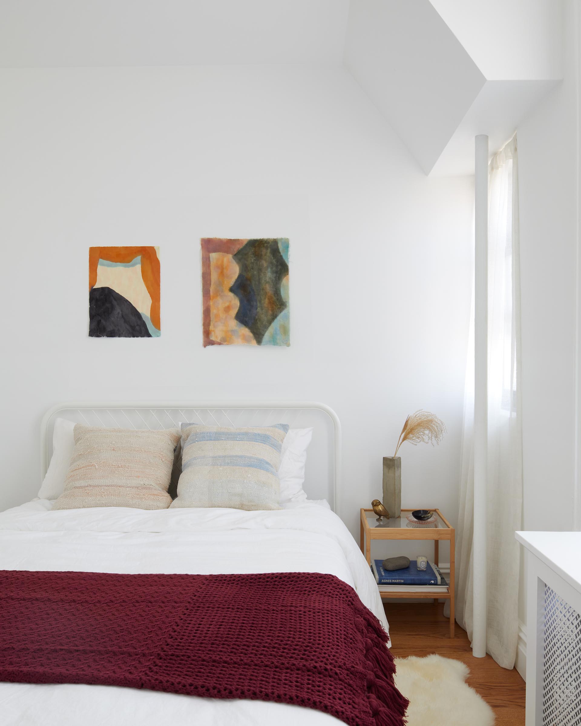 In this guest bedroom, bright and colorful accents stand out against the light-colored walls.