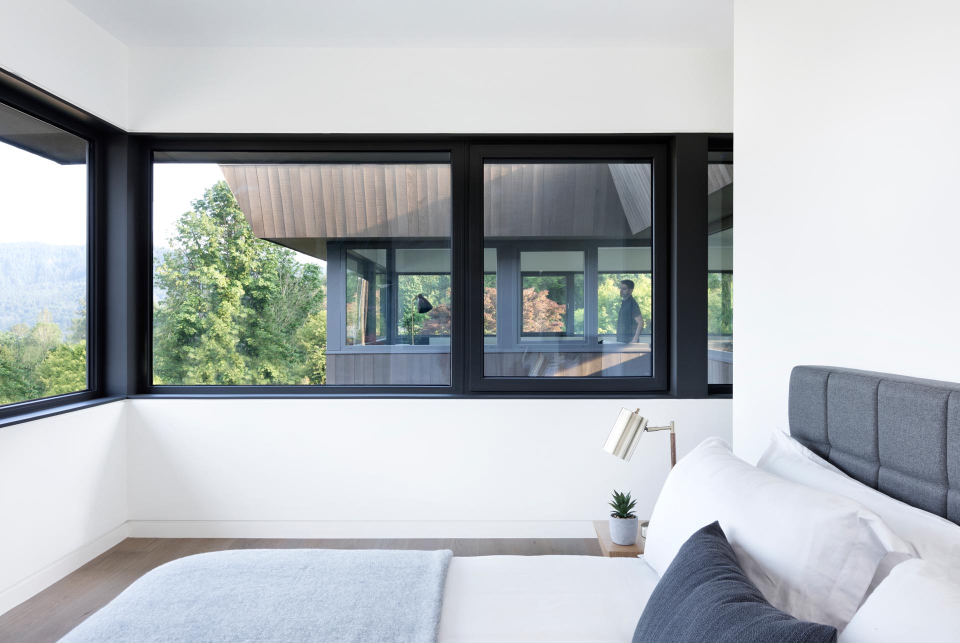 A modern bedroom with wrap around windows.