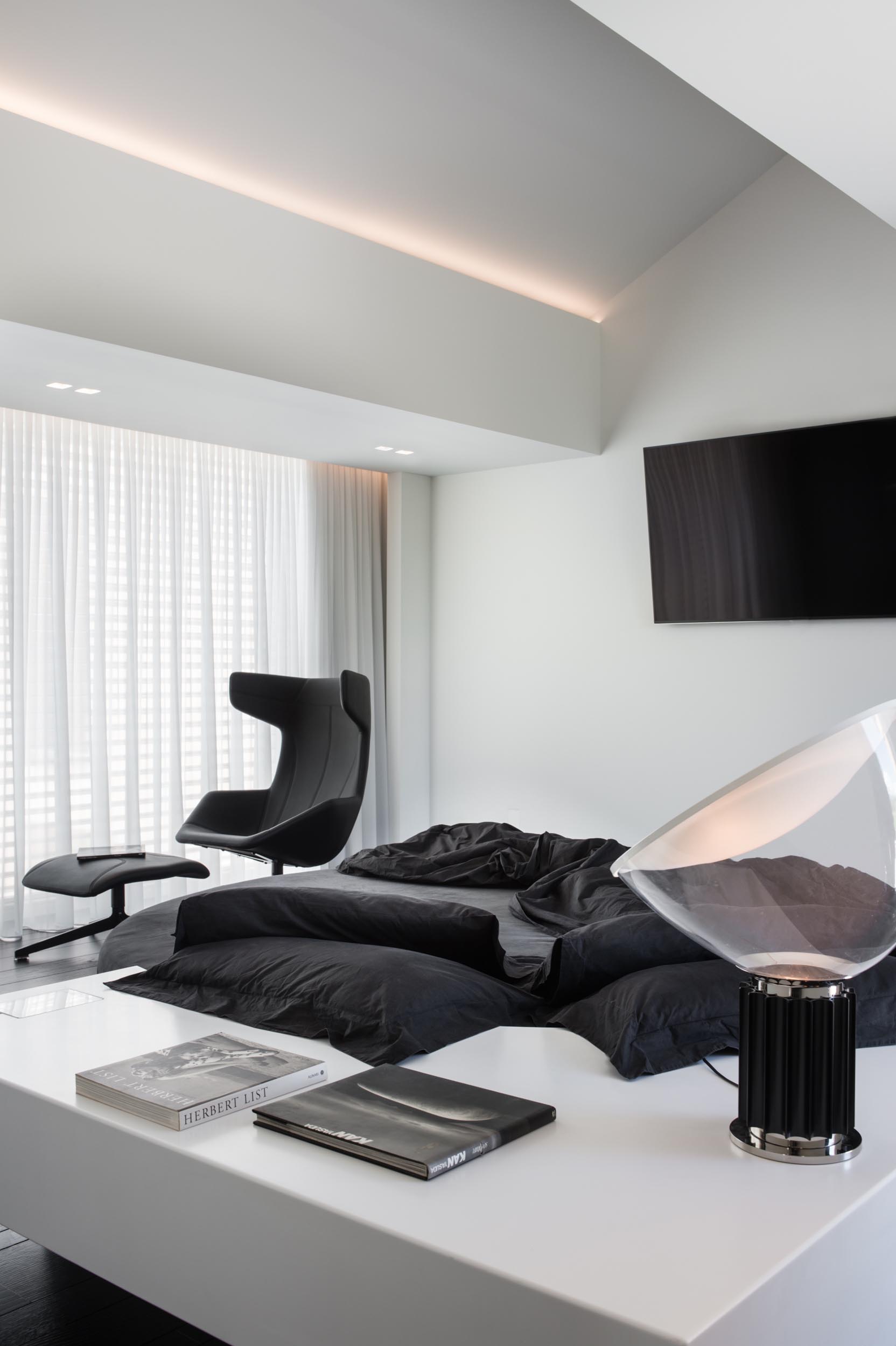 A modern bedroom with a black and white color theme.