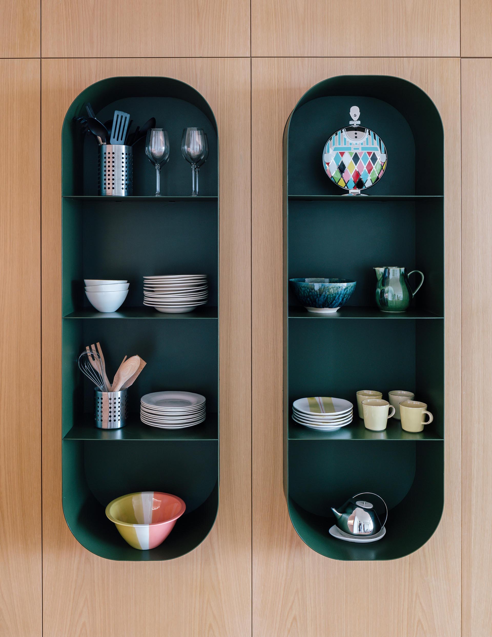 A modern dark green wall shelf with a curved design.