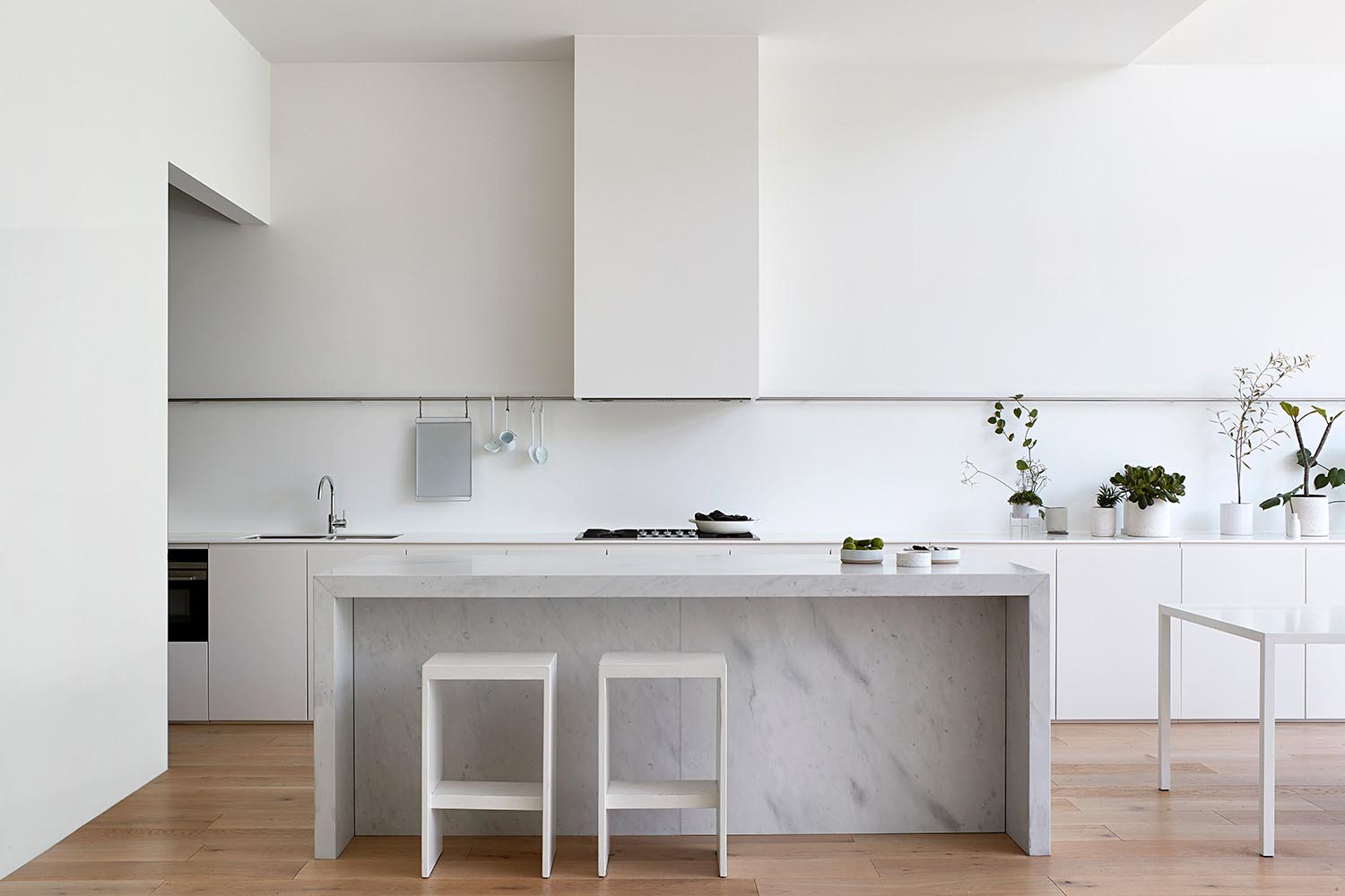 A modern white kitchen and stone island.