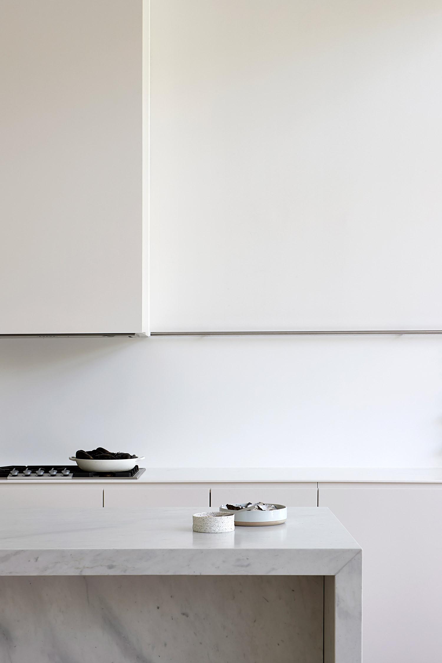 A modern white kitchen with an island.