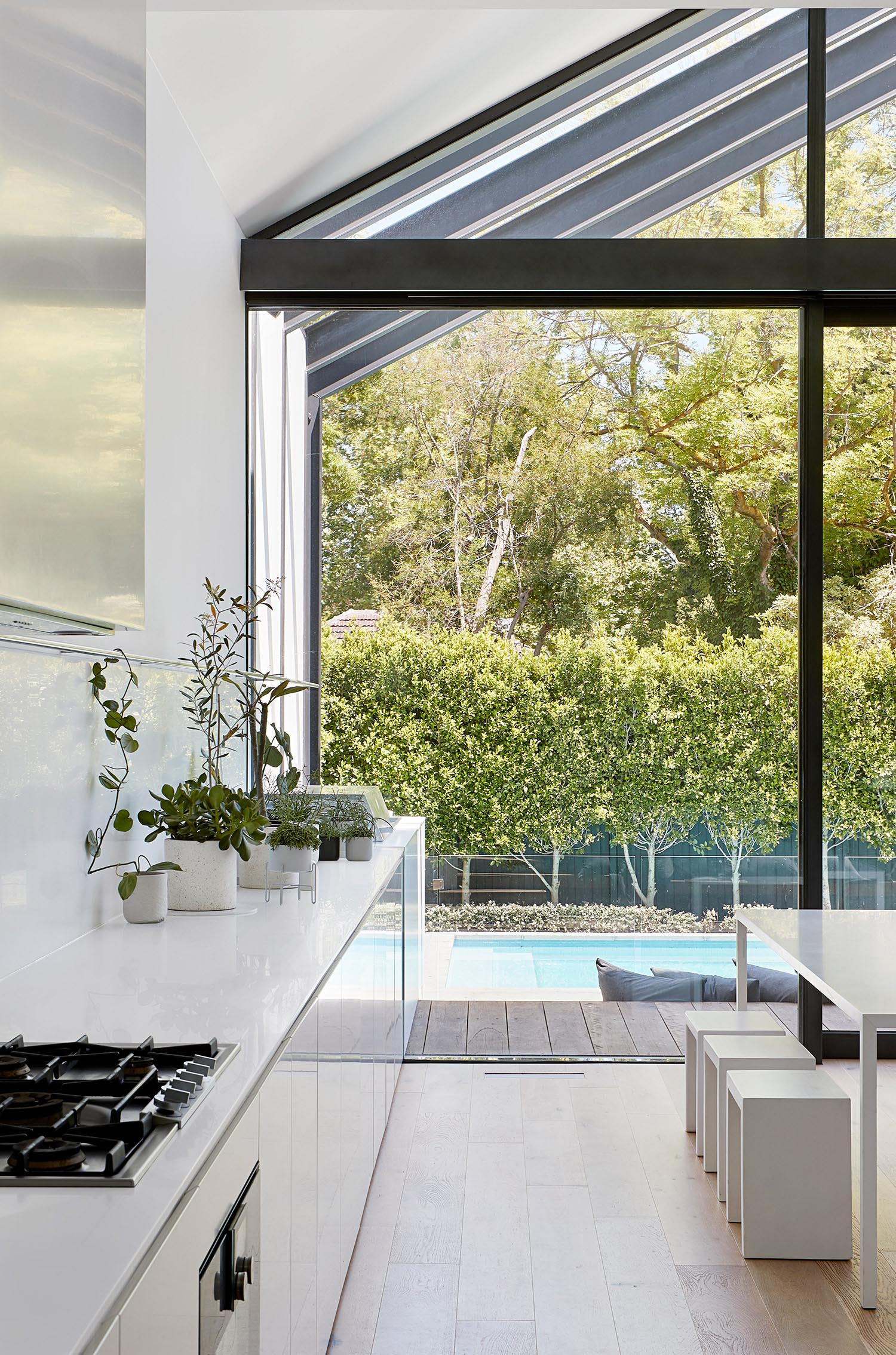 A modern white kitchen and dining room.