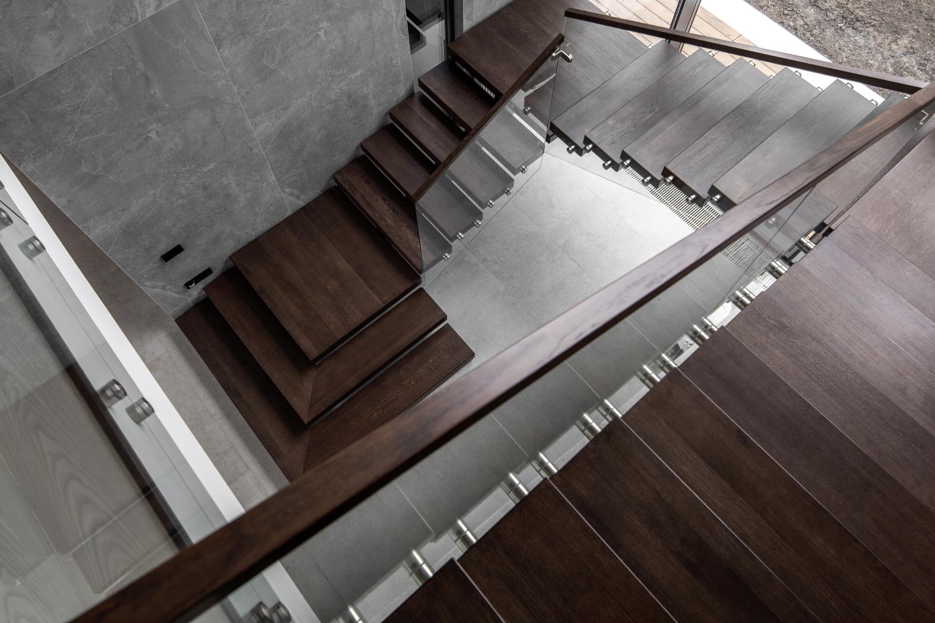 Modern wood stairs with glass railing.
