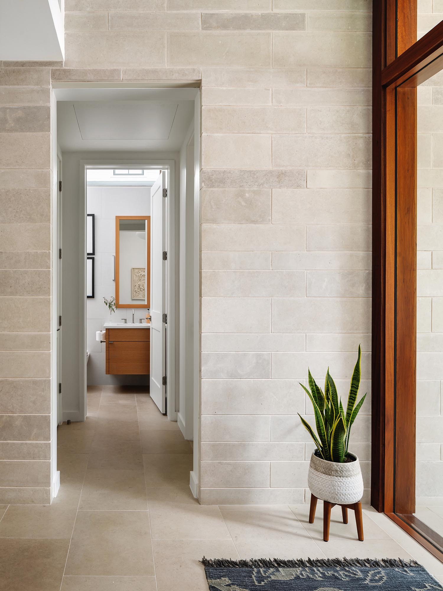 The Texas Lueders limestone on the exterior of the home continues through to the entryway.