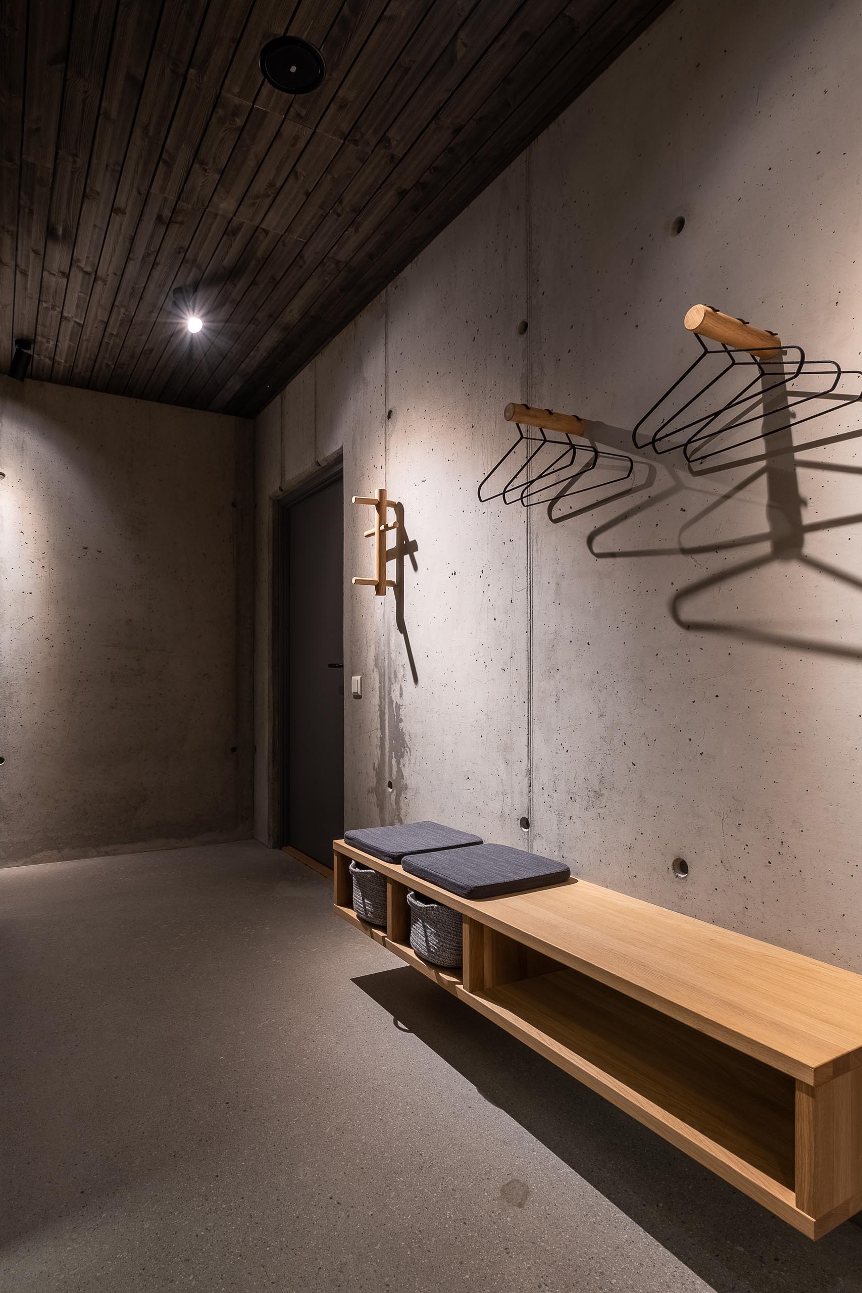 A concrete entryway with a floating wood bench.