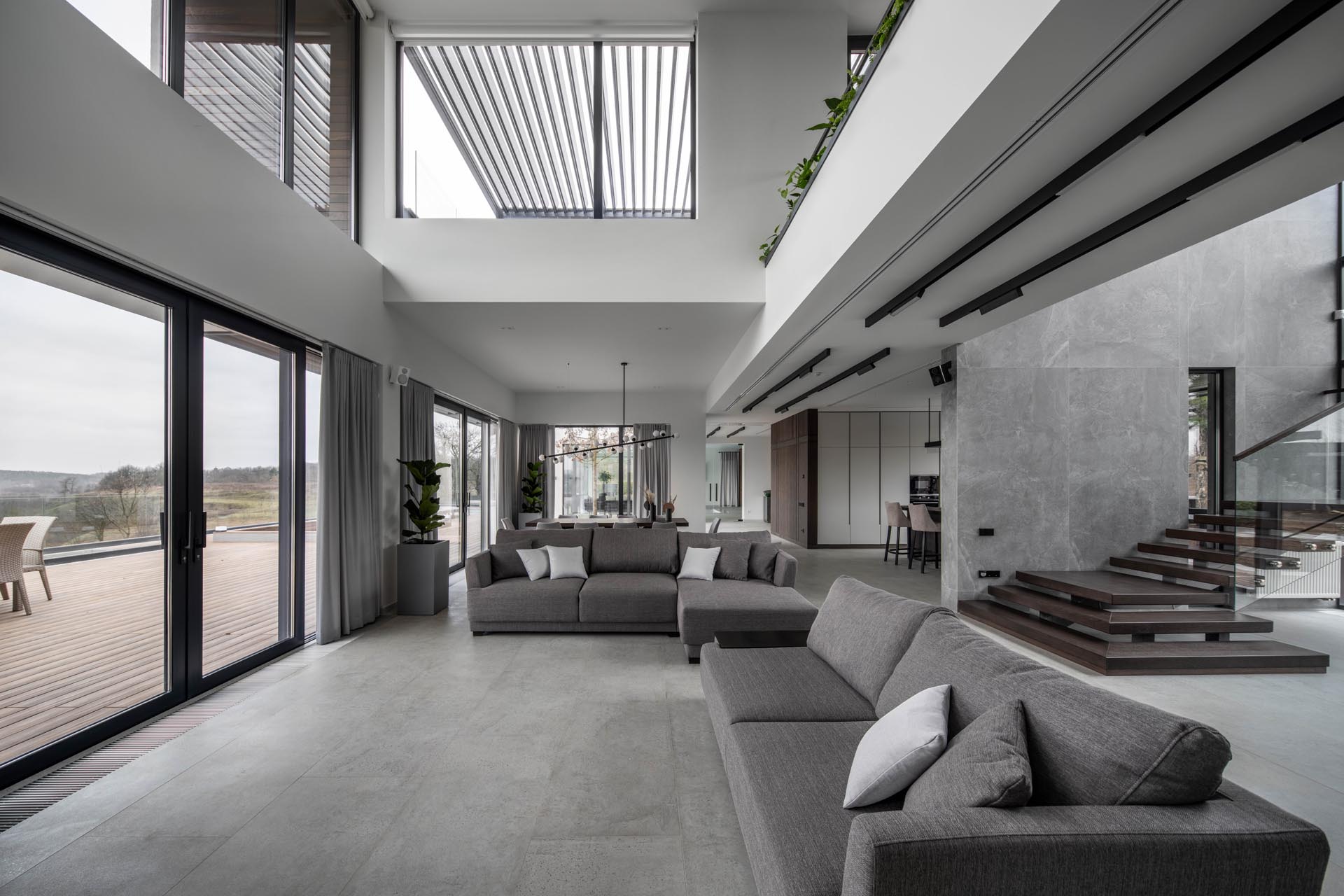 A modern living room with a gray color palette and double height ceiling.