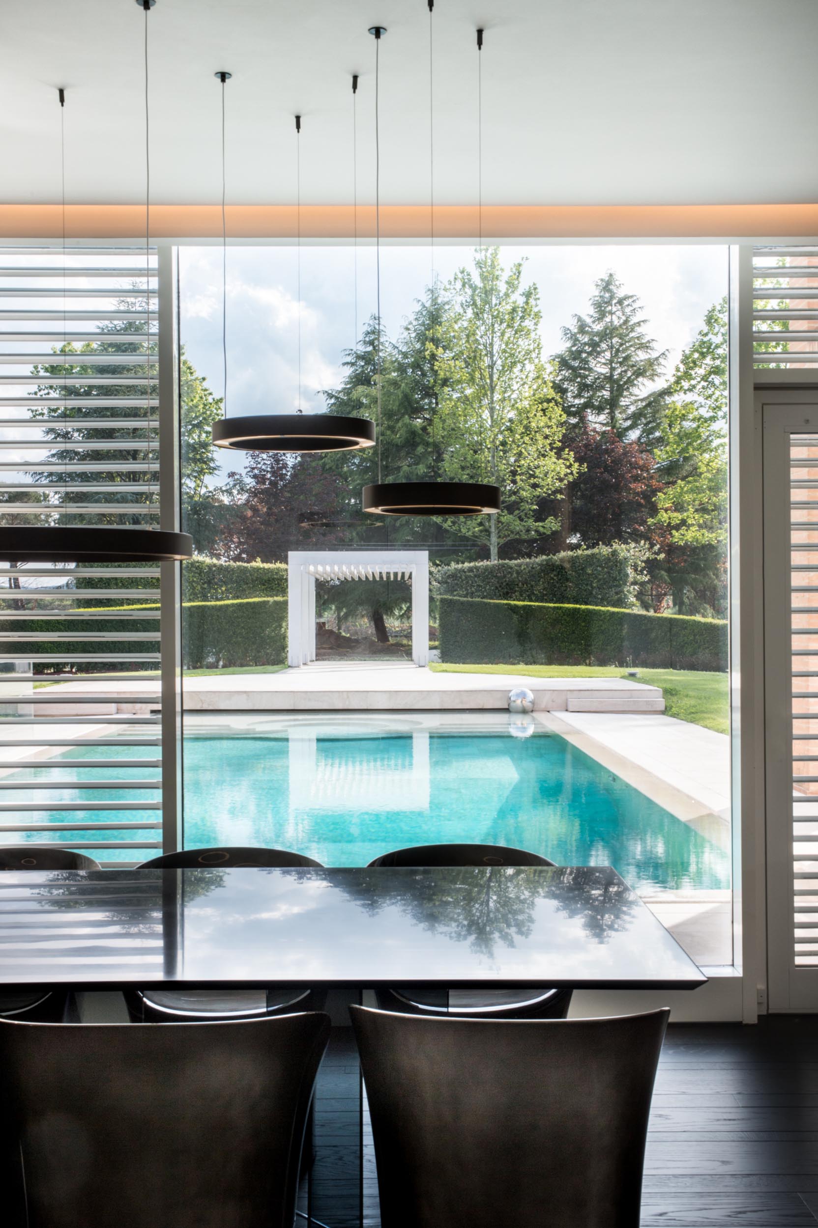 A modern dining room with a view of the pool.