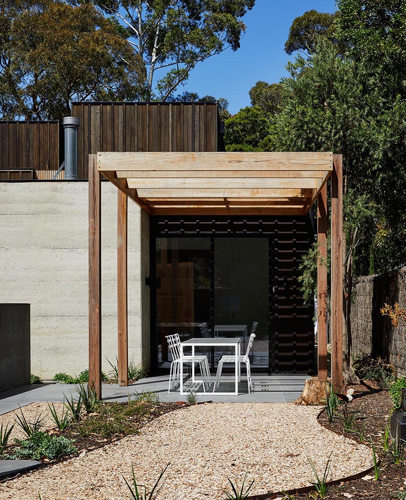 A blackbutt timber pergola leads to a landscaped garden.