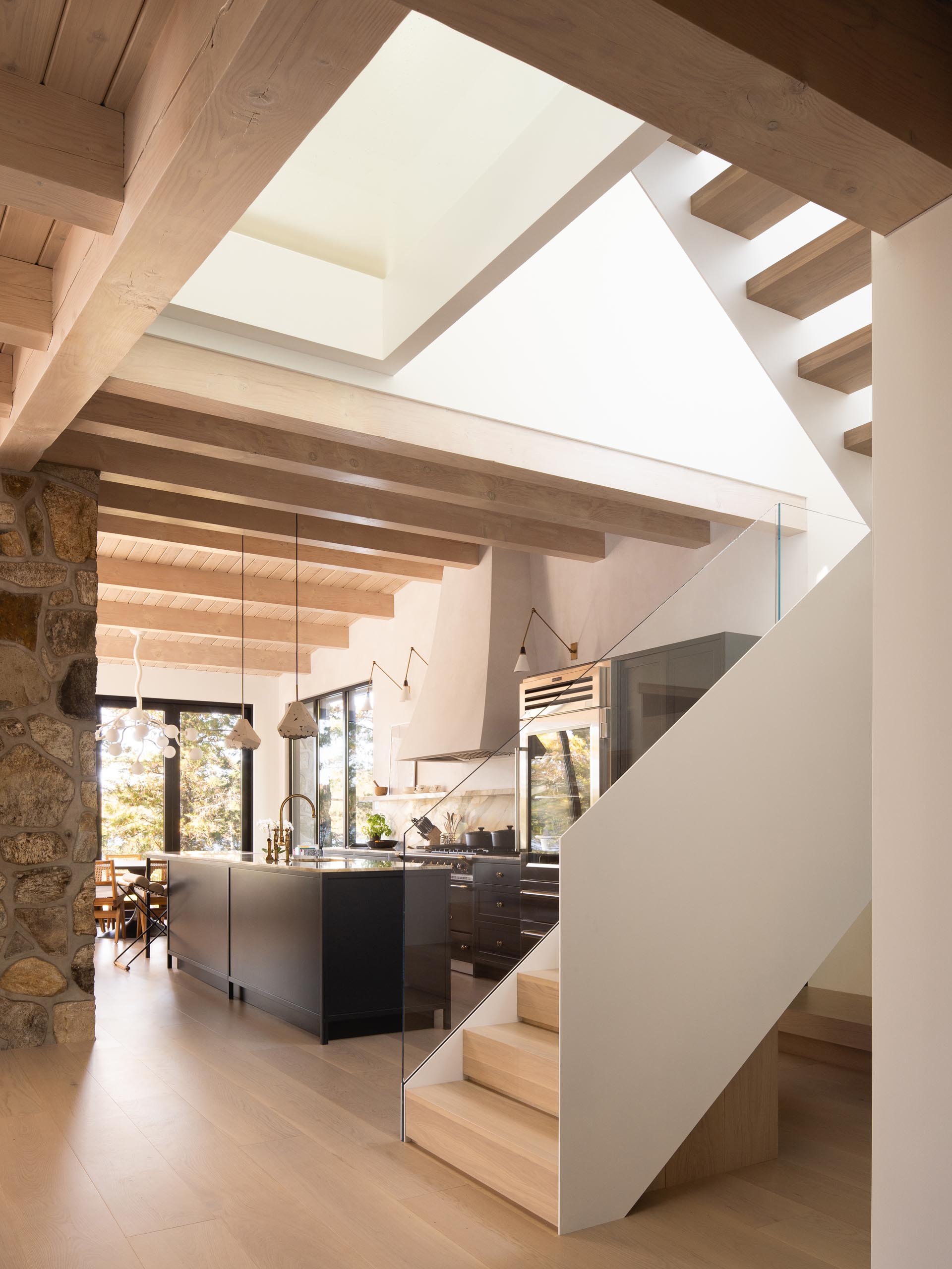 In this modern kitchen, matte black cabinets are topped with a light-colored marble countertop and backsplash.