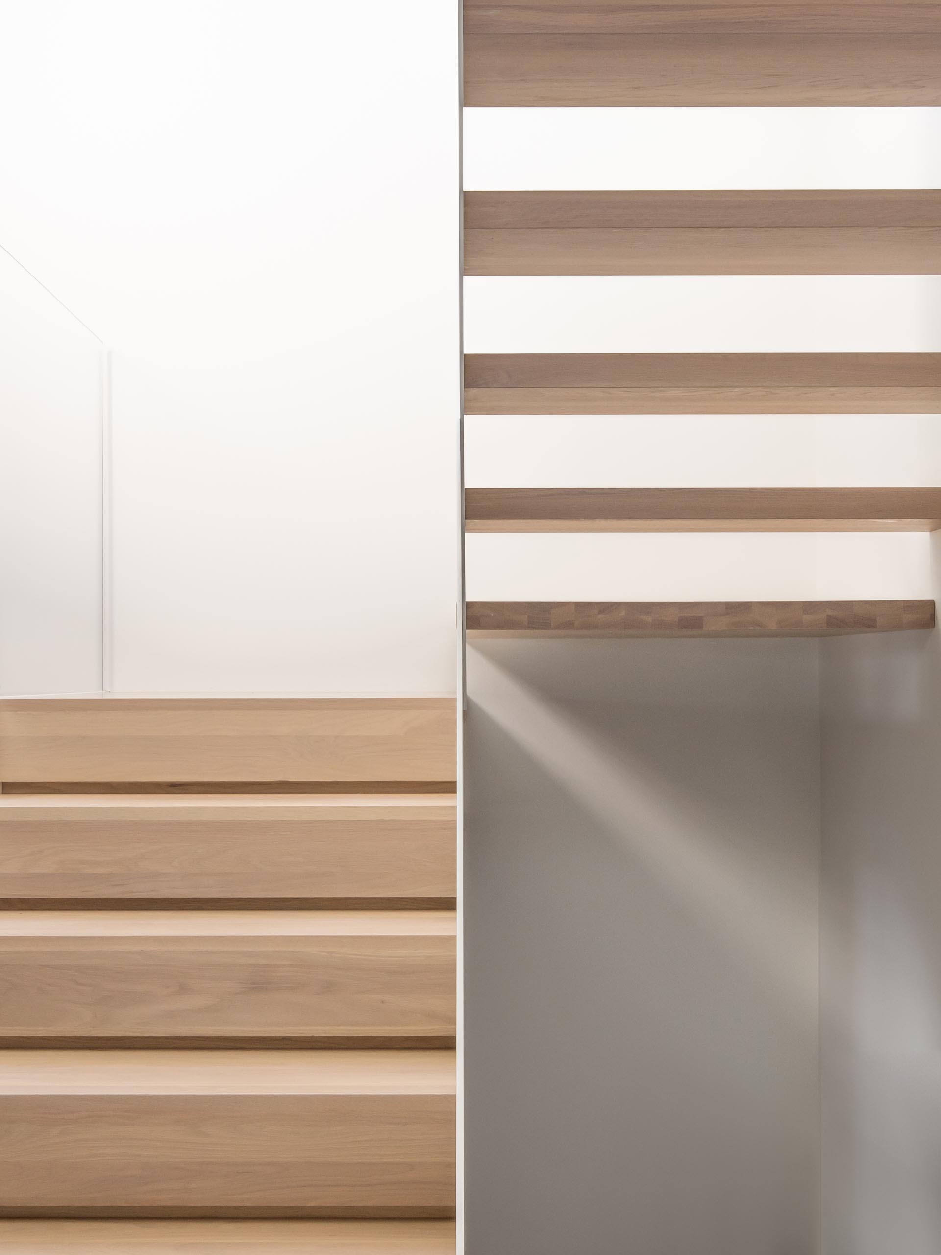 Modern white staircase with wood treads.