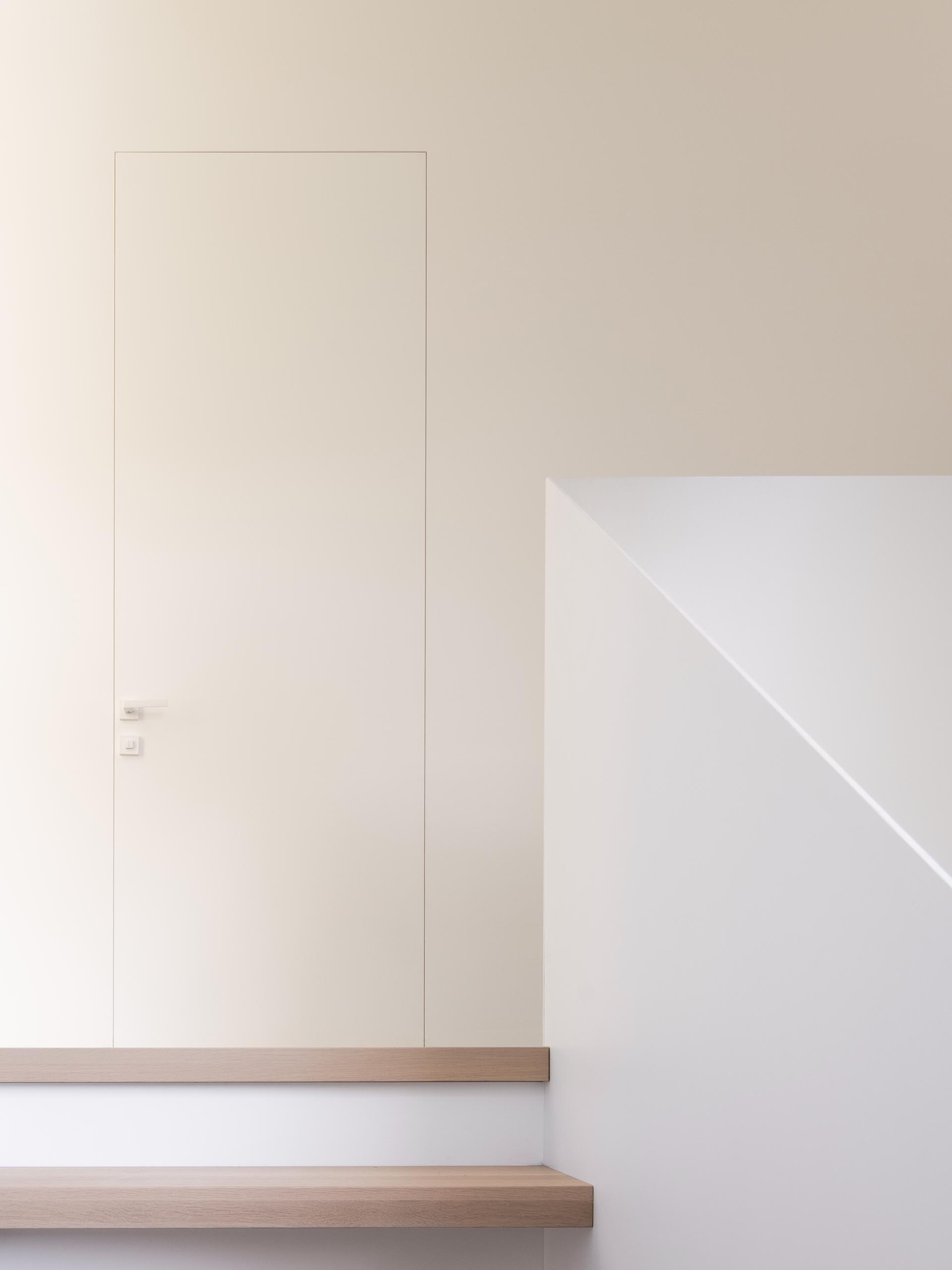 A minimalist door frame blends the door into the wall.