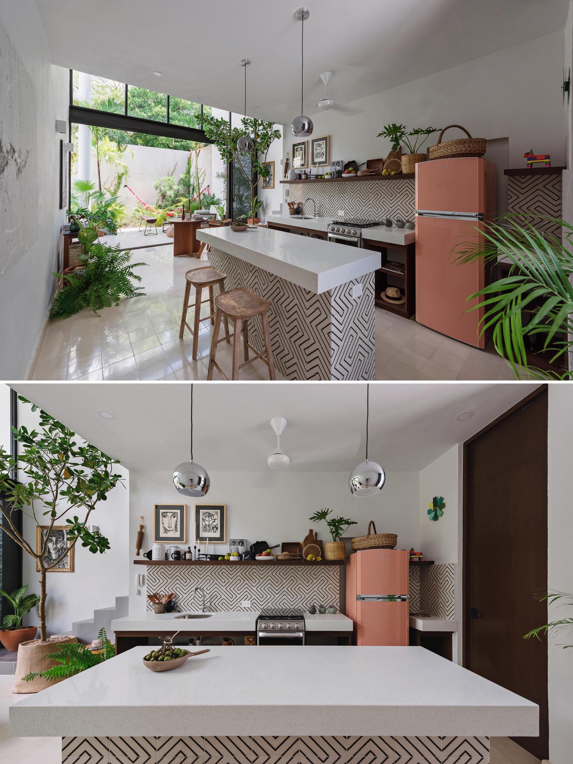 This small and modern kitchen includes thick white countertops and a graphic tile pattern.