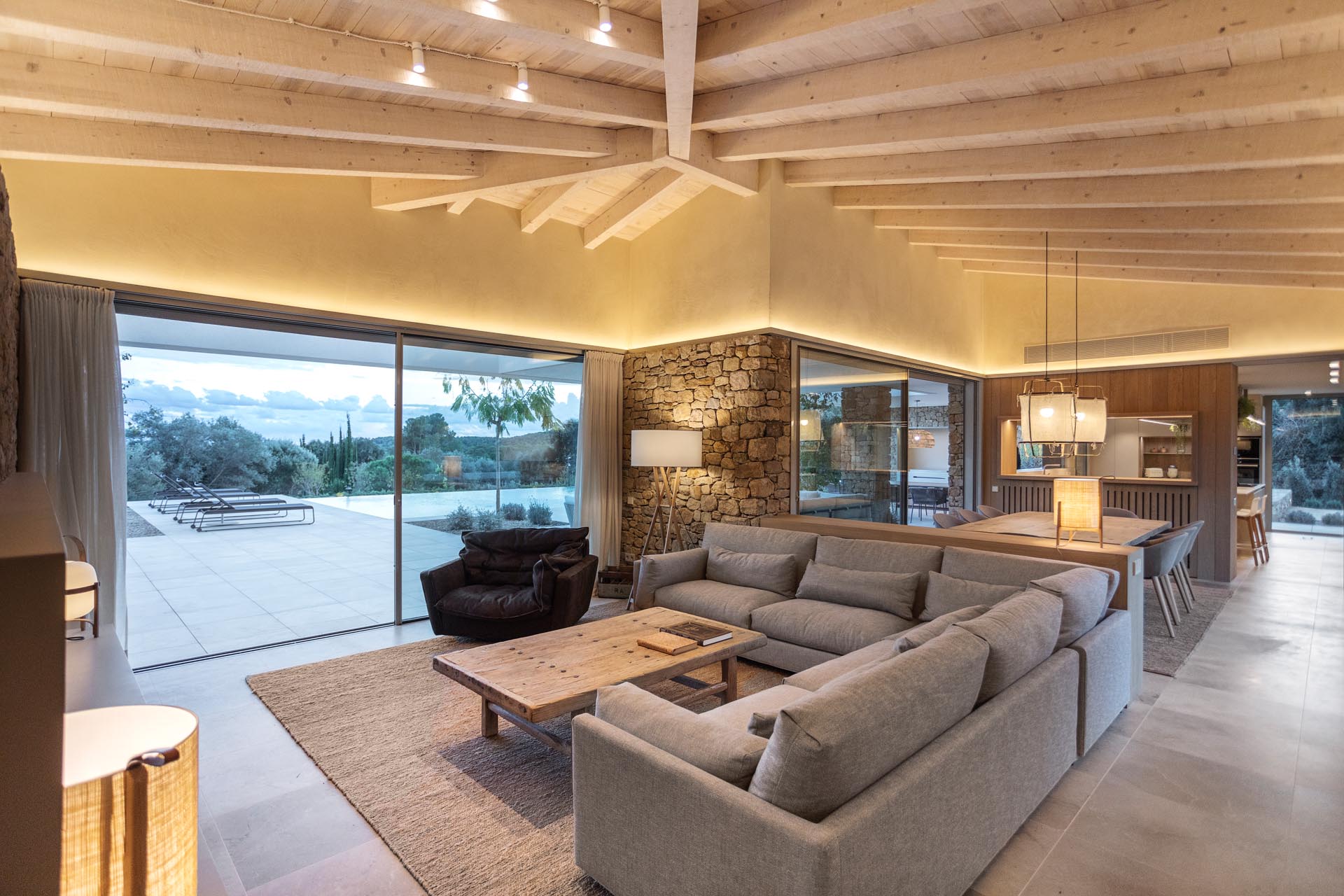 This modern house has stone walls and an open plan living room and dining room.