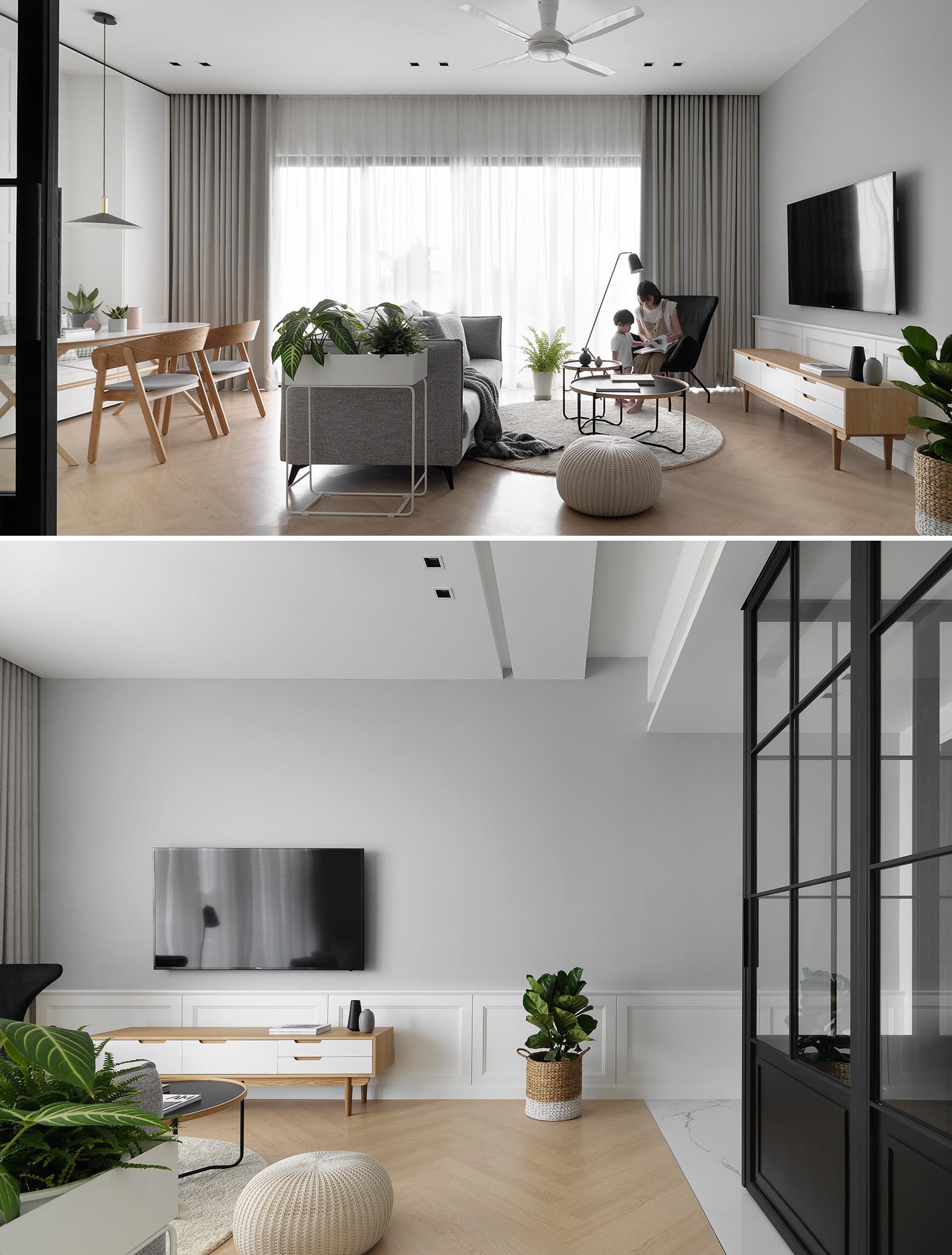 In the living room of a modern apartment, a gray accent wall, floor-to-ceiling curtains, and sofa, complement the light wood tones and white accents.