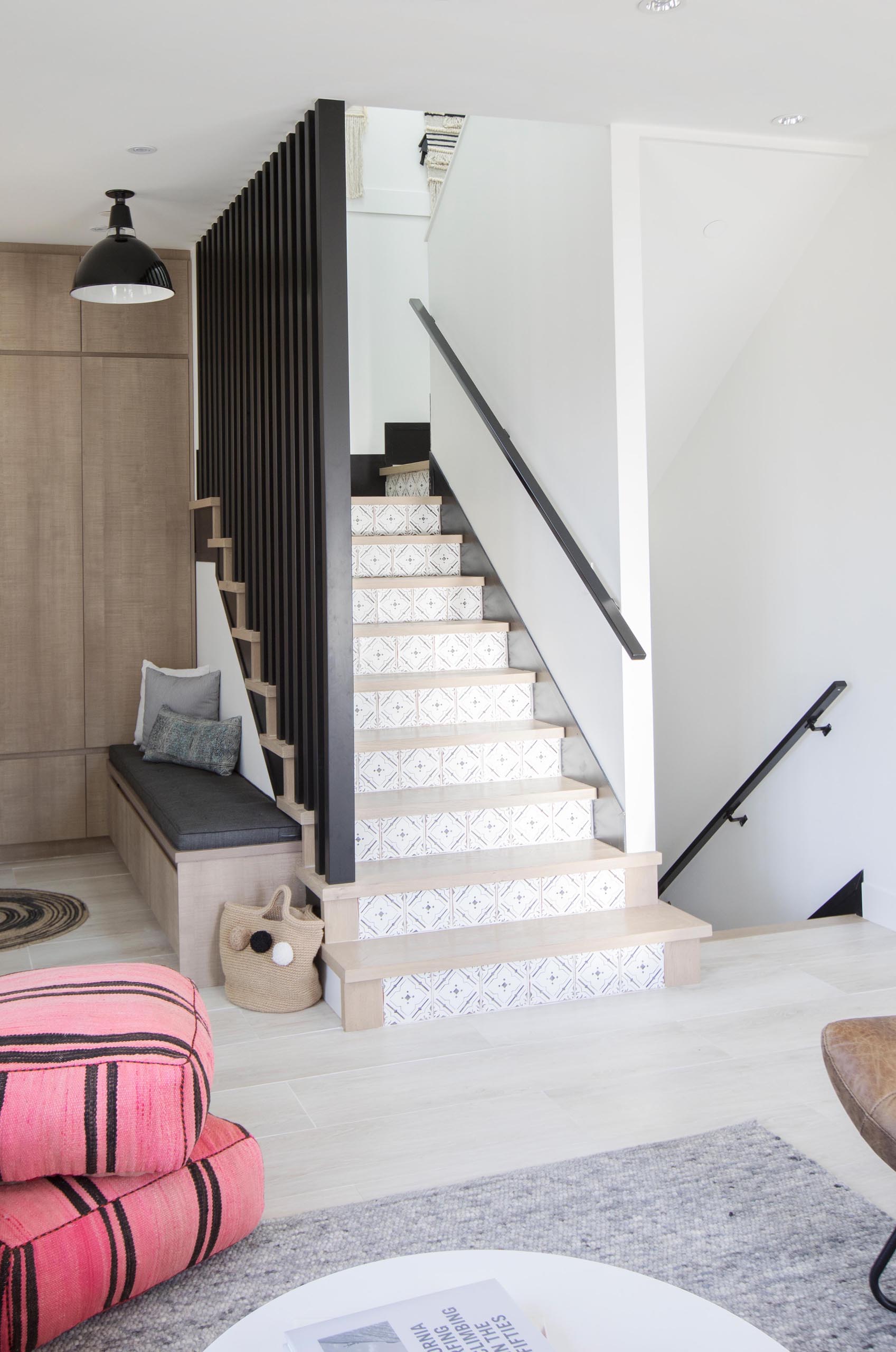 These modern stairs have a delicate pattern that's shown on the risers, while the black handrails complement other black accents throughout the home.