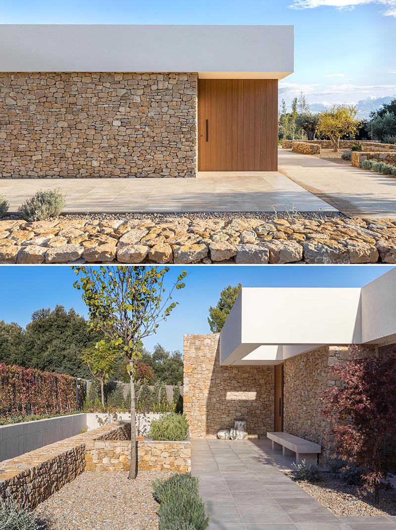 A modern stone house with a smooth white upper section.