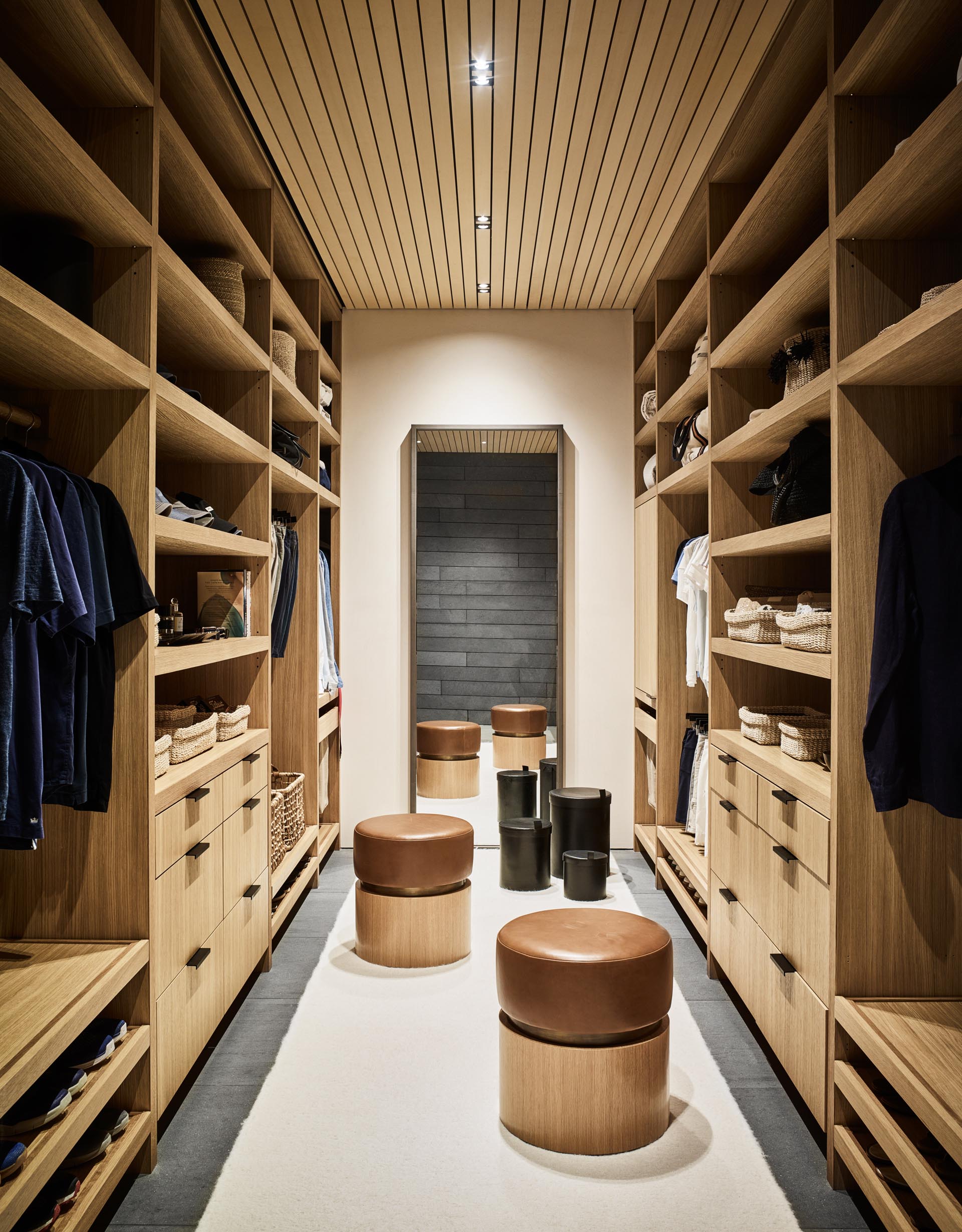 A modern walk-in closet with a floor-to-ceiling shelving, drawers, and space for hanging clothes.