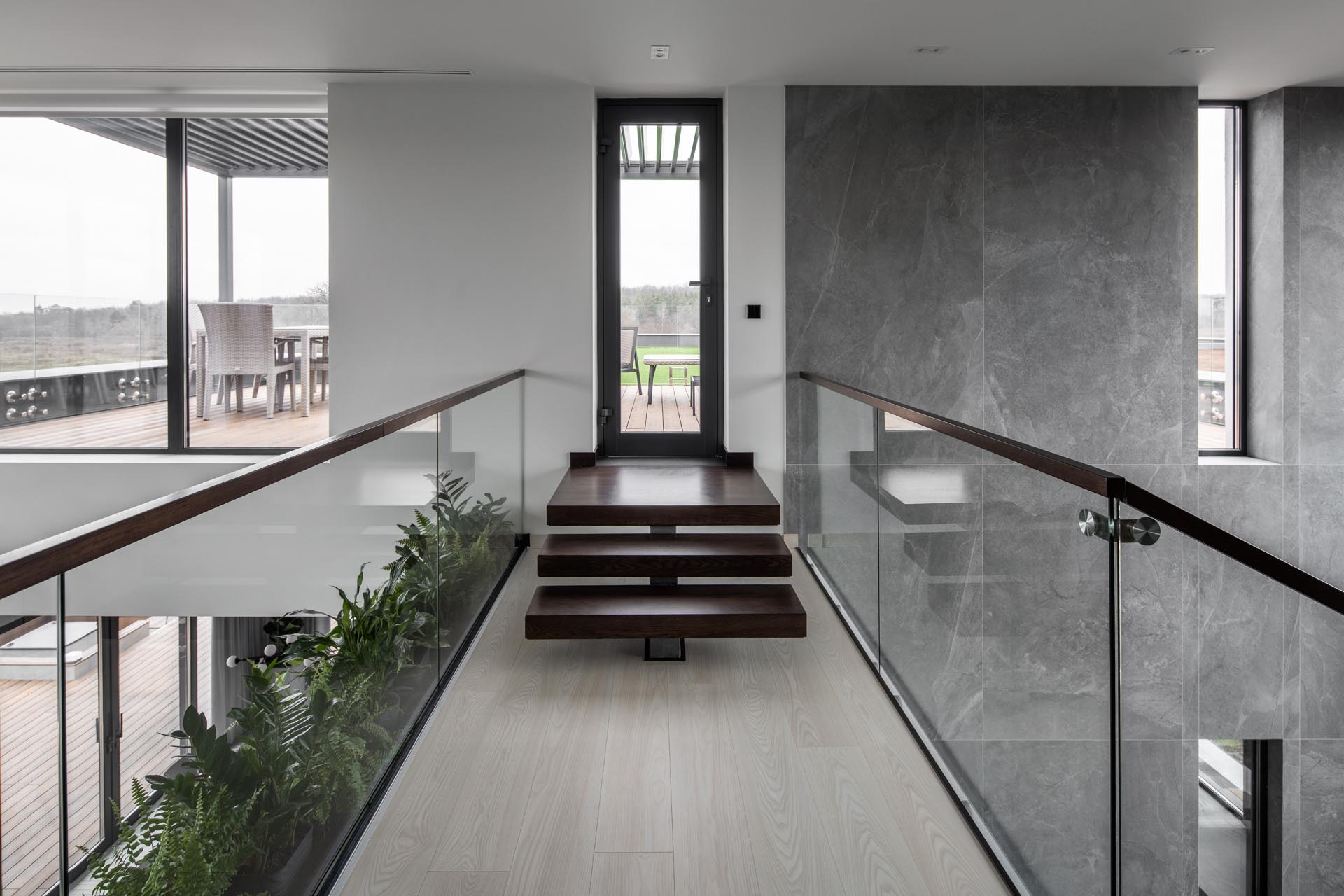 An open walkway with built-in planters and glass railings.