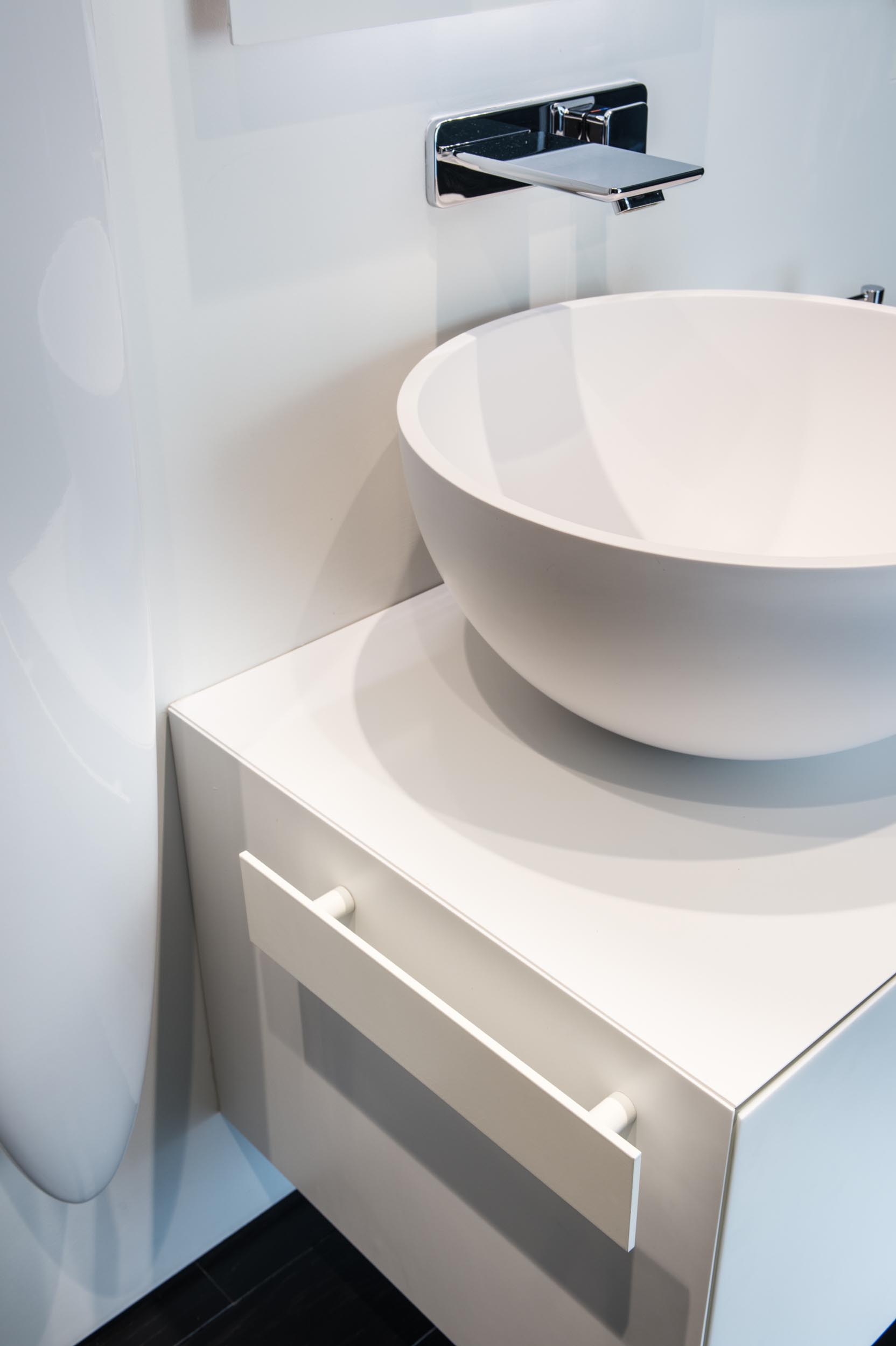 A modern bathroom with a white vanity and backlit mirror.