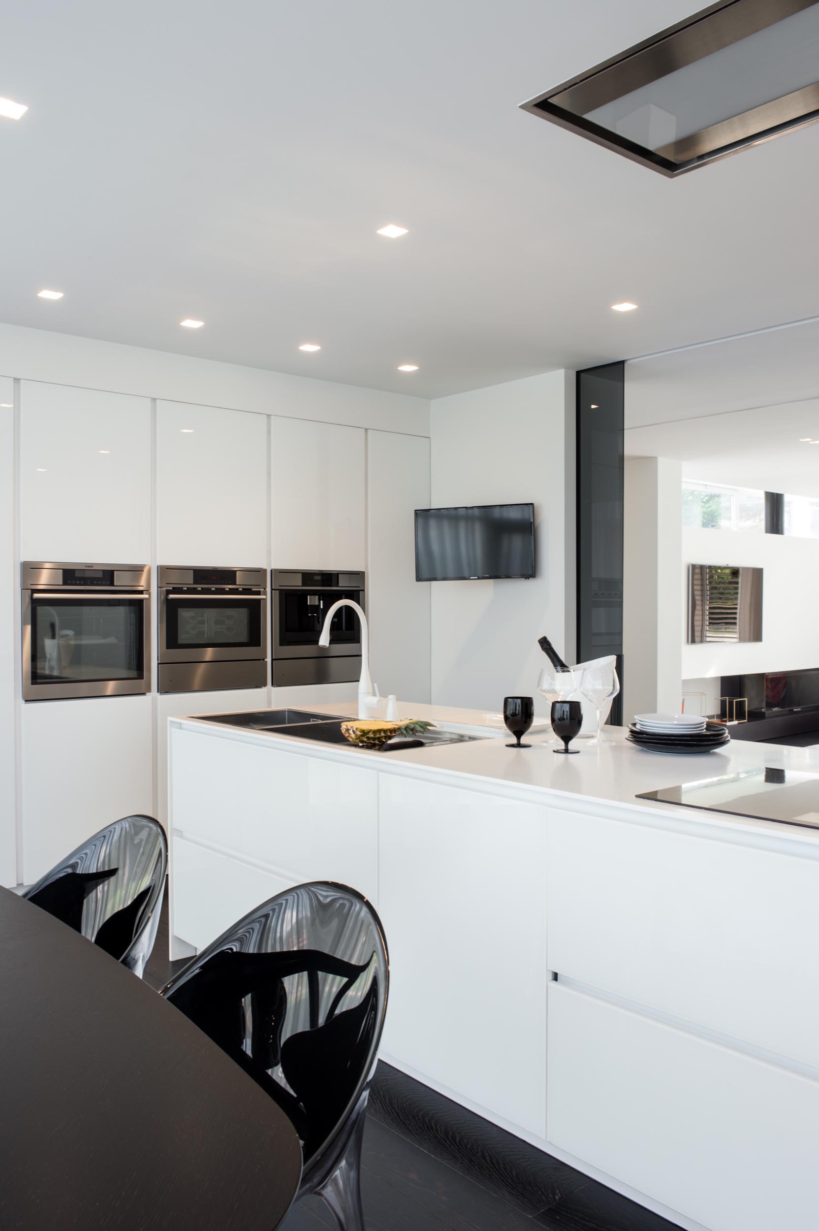 A modern kitchen with minimalist white cabinets.